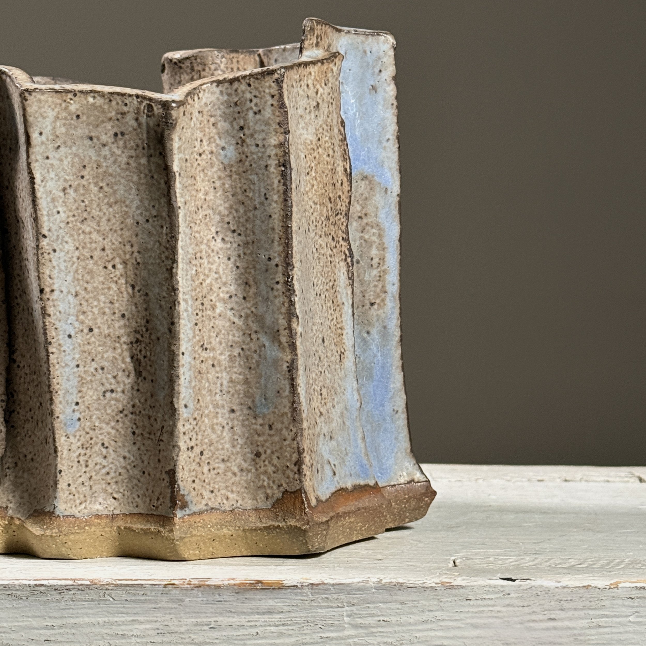 Detail of grey speckled glaze surface with blue accents.