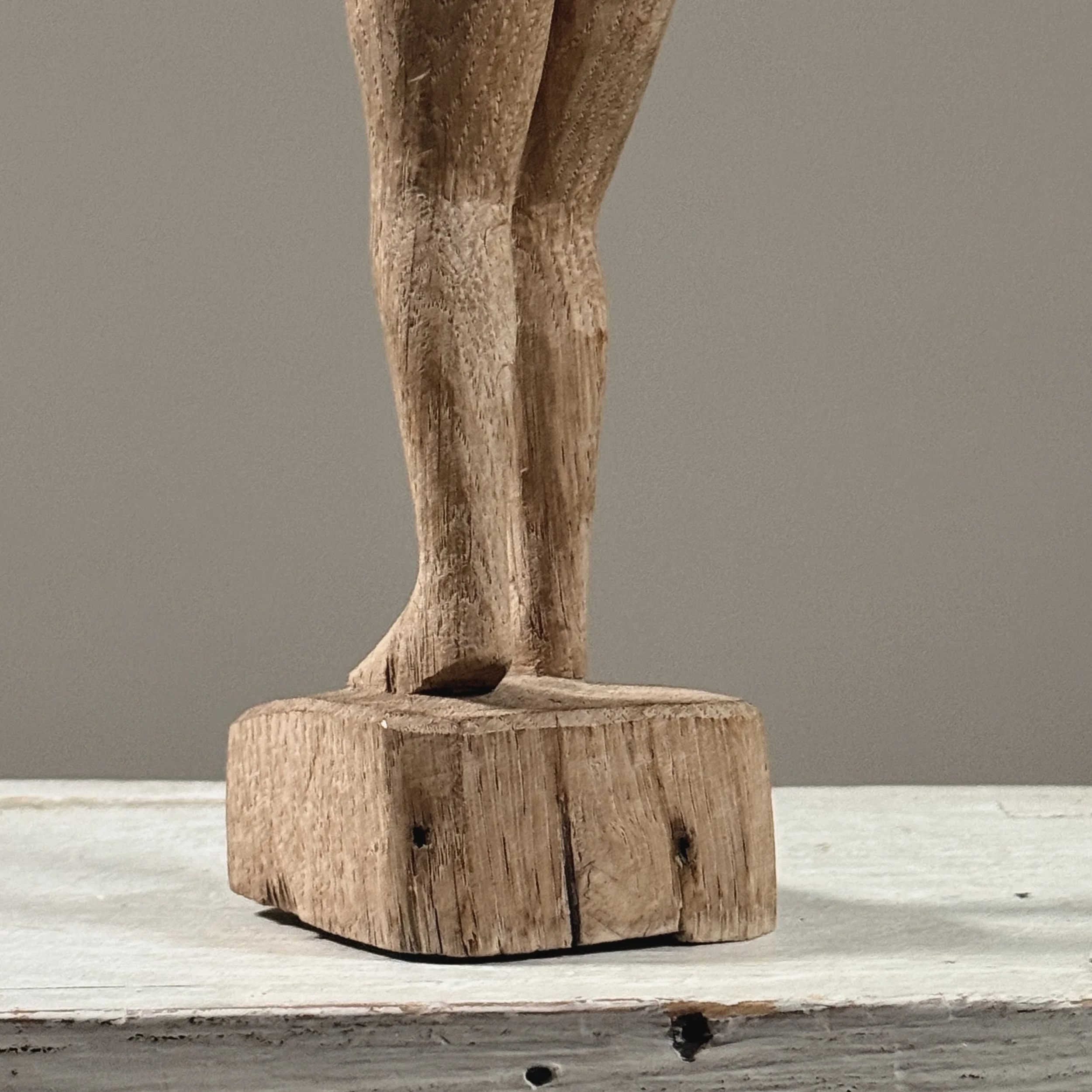 Detail view of integral base on vintage hand carved wood female nude sculpture, modernist style