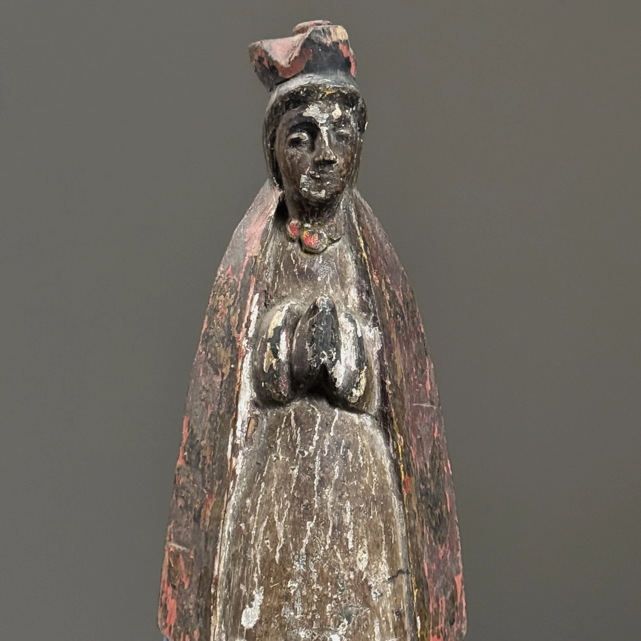 Close-up of the sculpture's surface, highlighting the crackled polychrome, patina, and exposed wood grain.