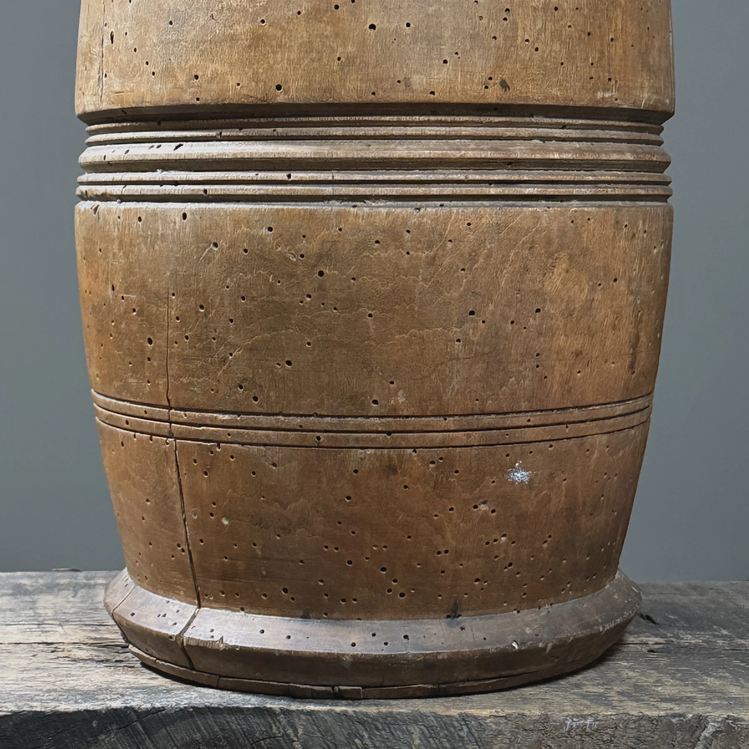 Front view of antique treenware barrel with concentric ribbed bands