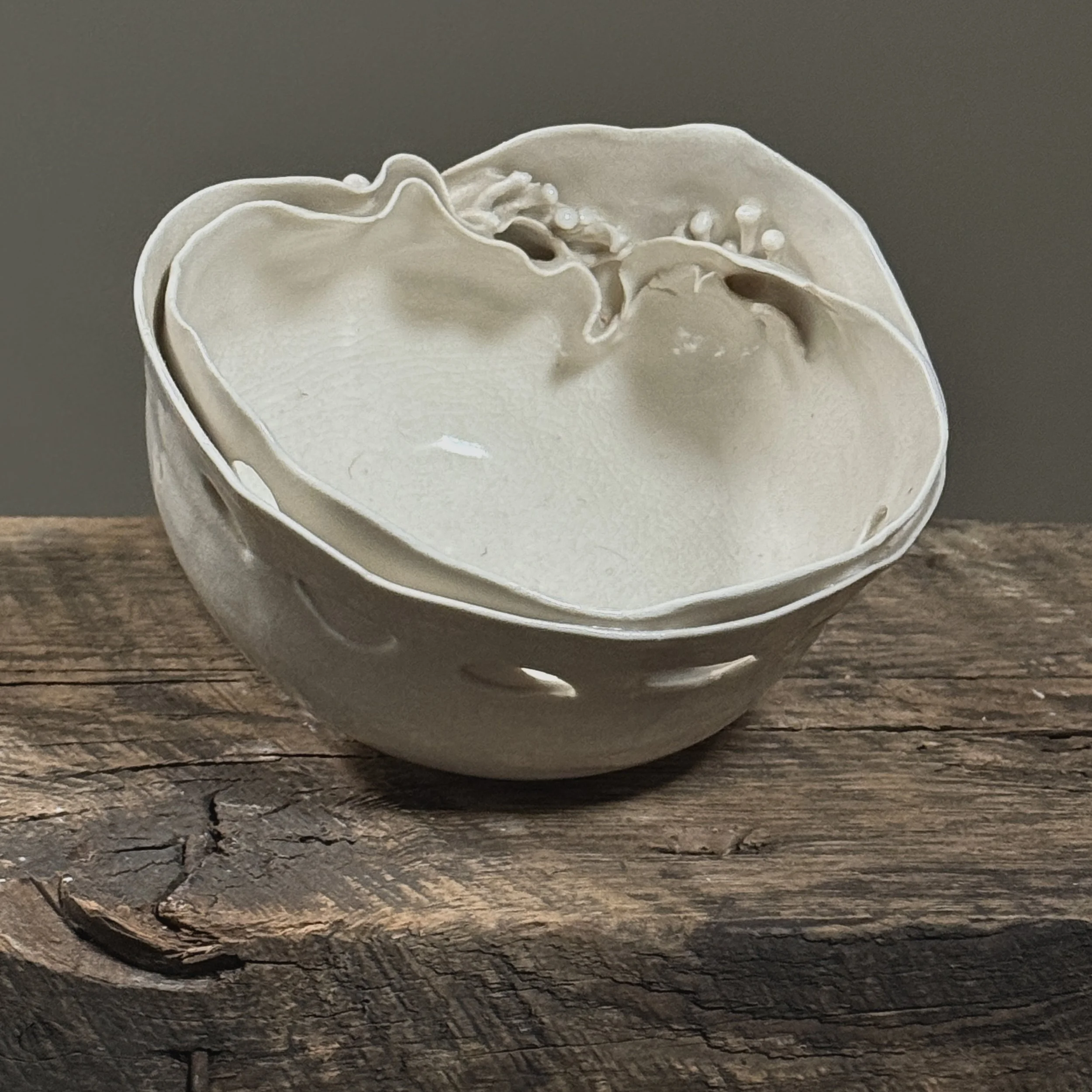 White porcelain vessel with overlapping perforations