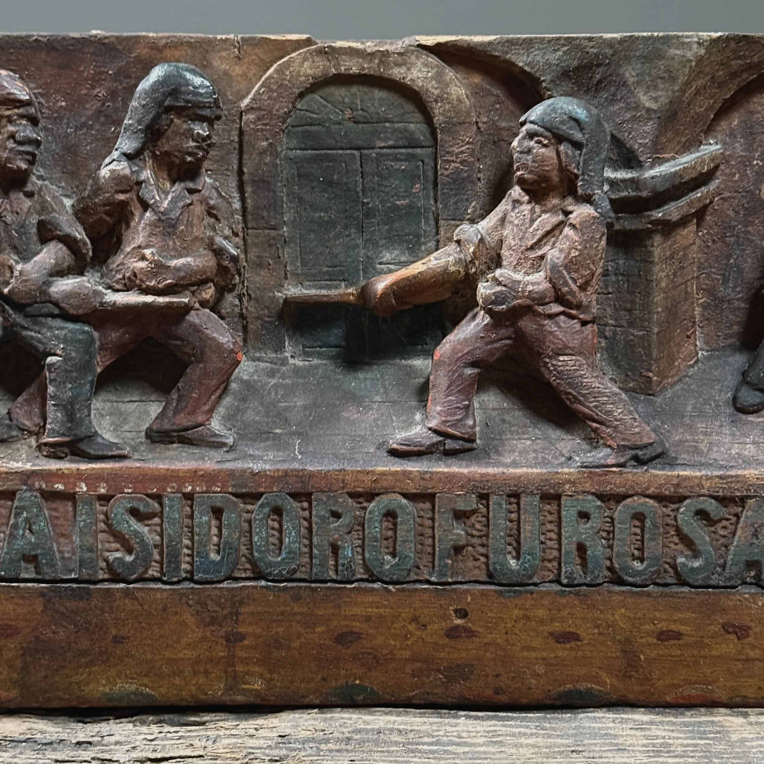 Detail of sword fight. Four male figures. Carved narrative composition.