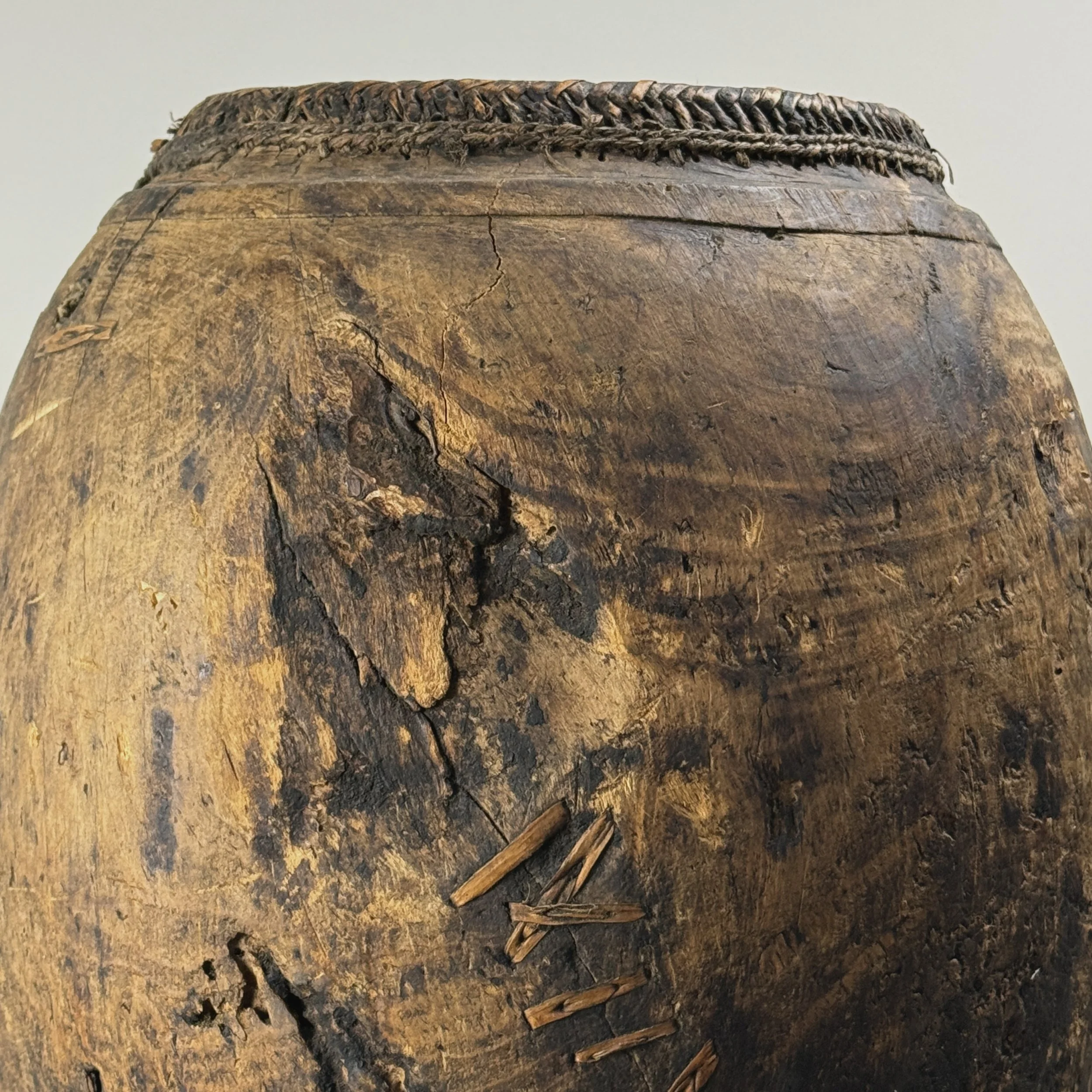 Hand carved wood vessel with visible patination and woven wood inset.