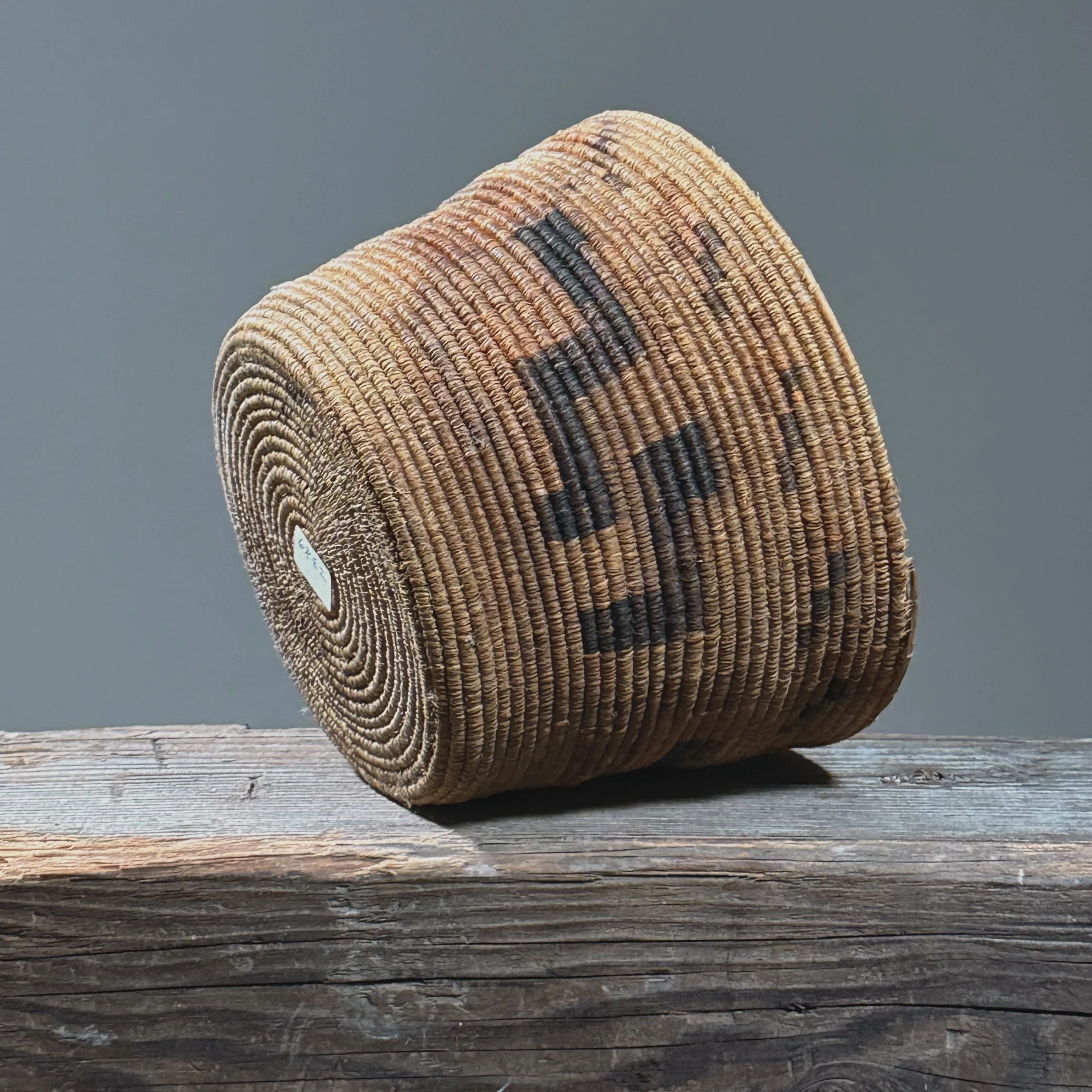 Full frontal view of an antique Tohono O'odham coiled basket with geometric step pattern