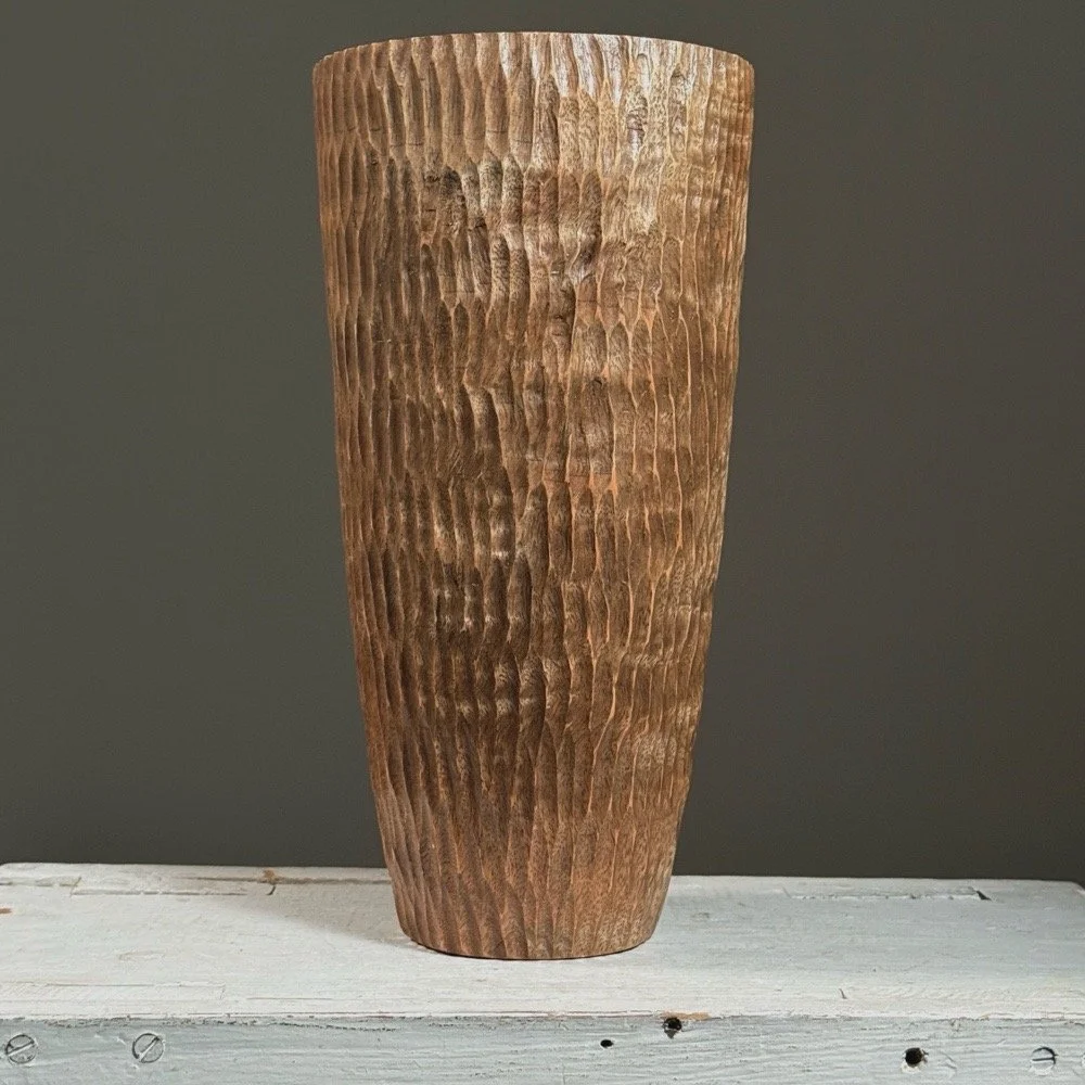 Front view of a vintage folk art chip-carved cylindrical wood vase.
