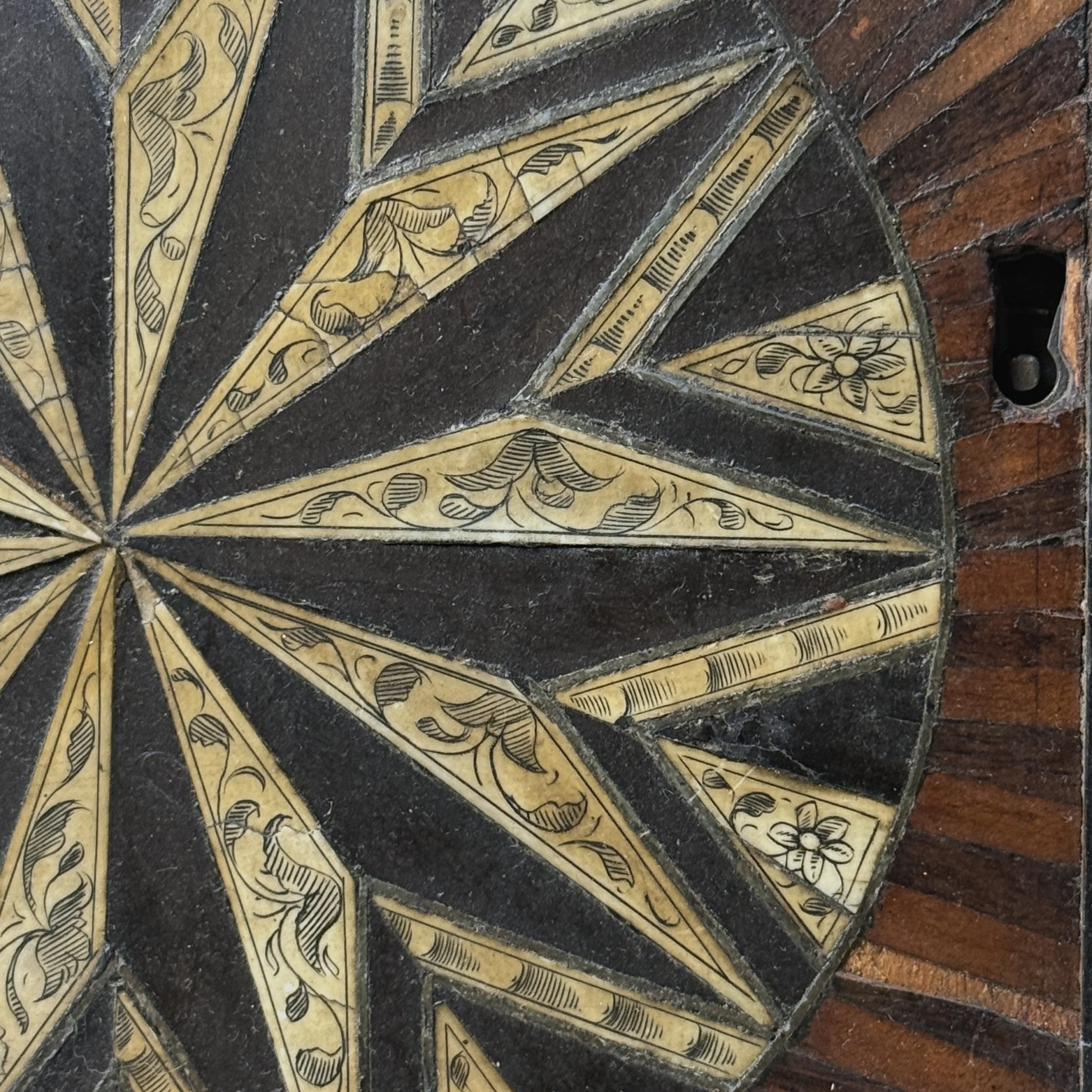 Sunburst detail. Geometric wood inlay. Symmetrical pattern.