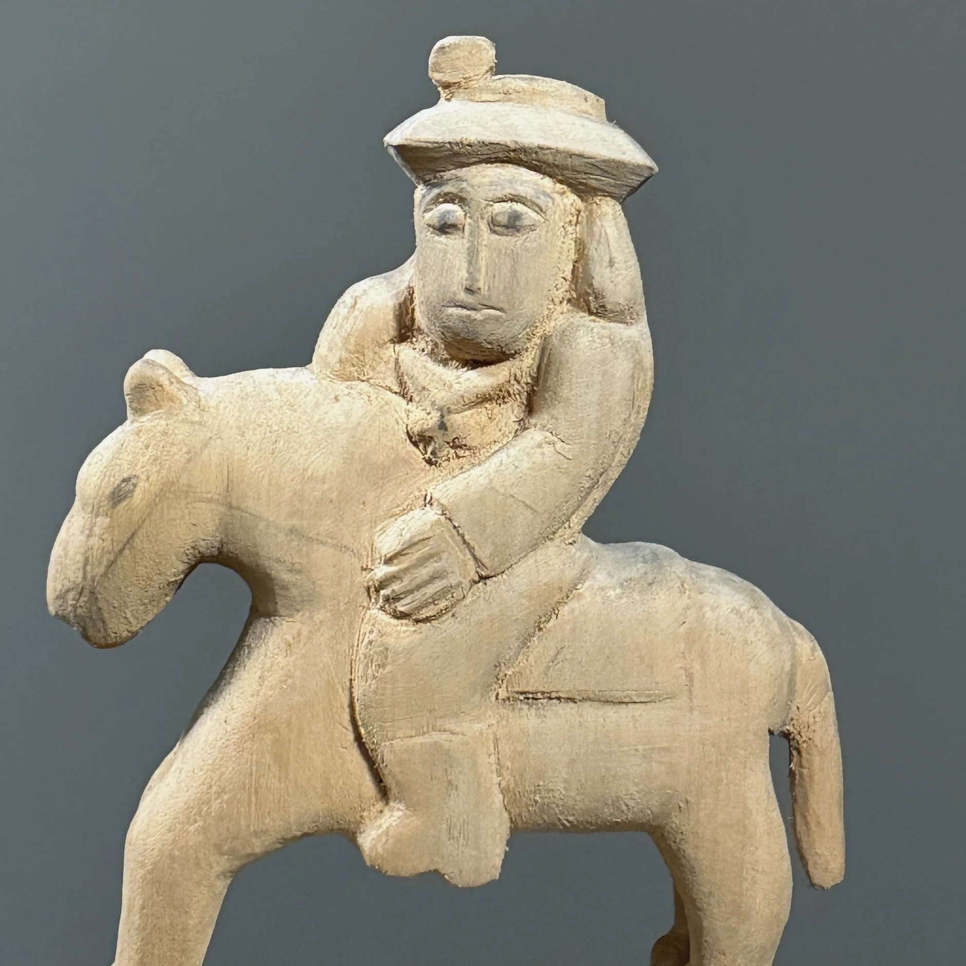 Close-up of the rider figure and the raw wood texture.