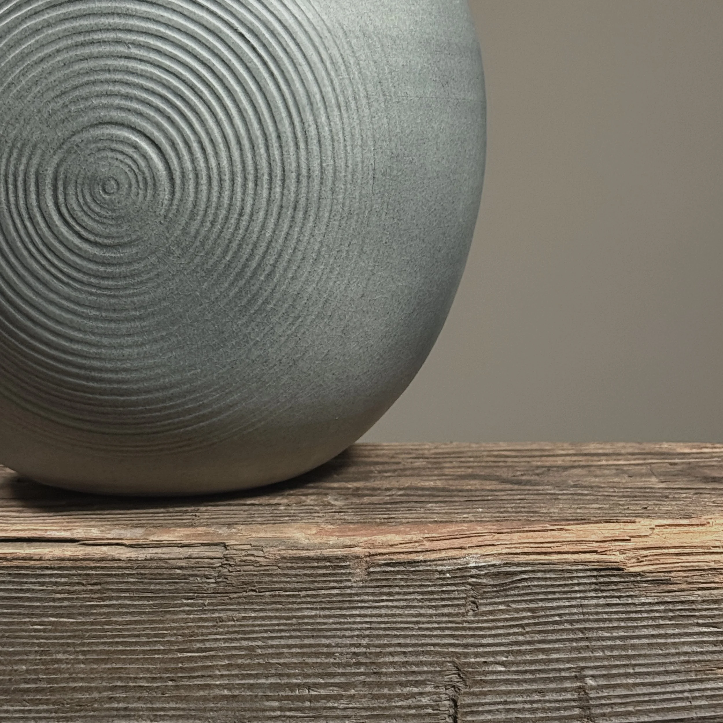 Detail of etched swirl design on muted grey-blue surface