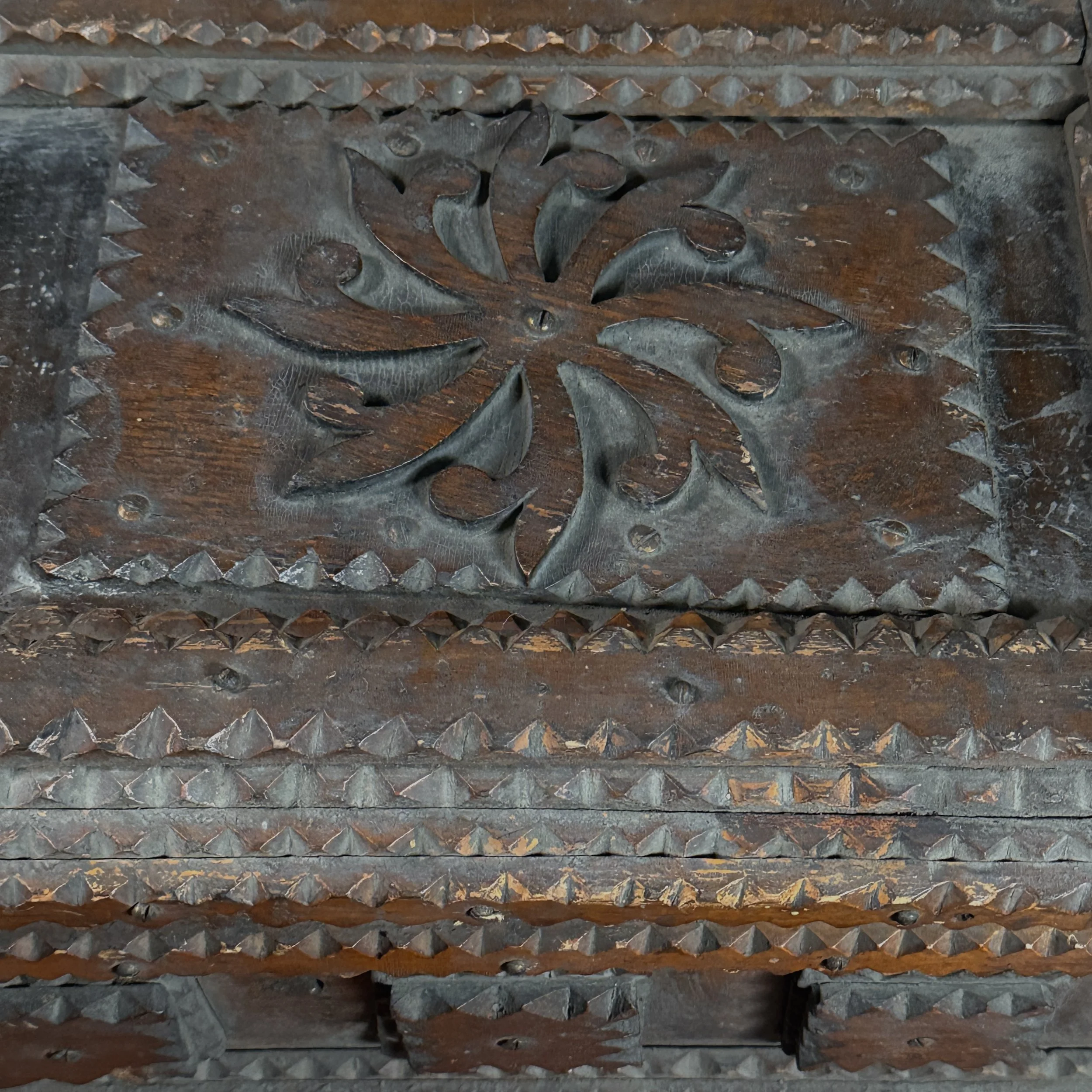 Detail shot of the central scrollwork medallion on the chest's lid.