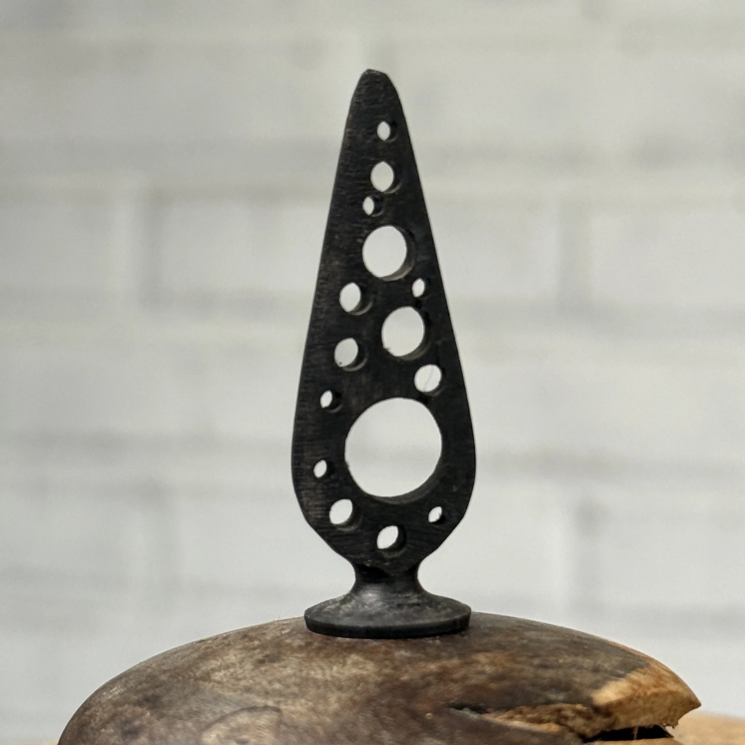 Hand-carved ebony stopper with cutout detailing on burl wood vessel