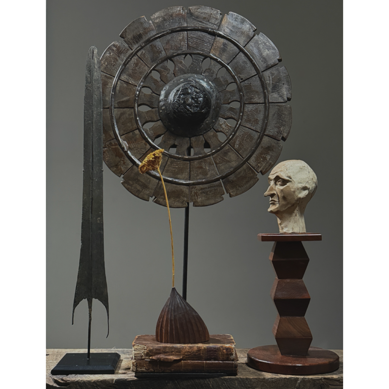 Vignette with Antique hand carved folk art charkha wheel. Traditional Indian spinning wheel. 27 inches high.