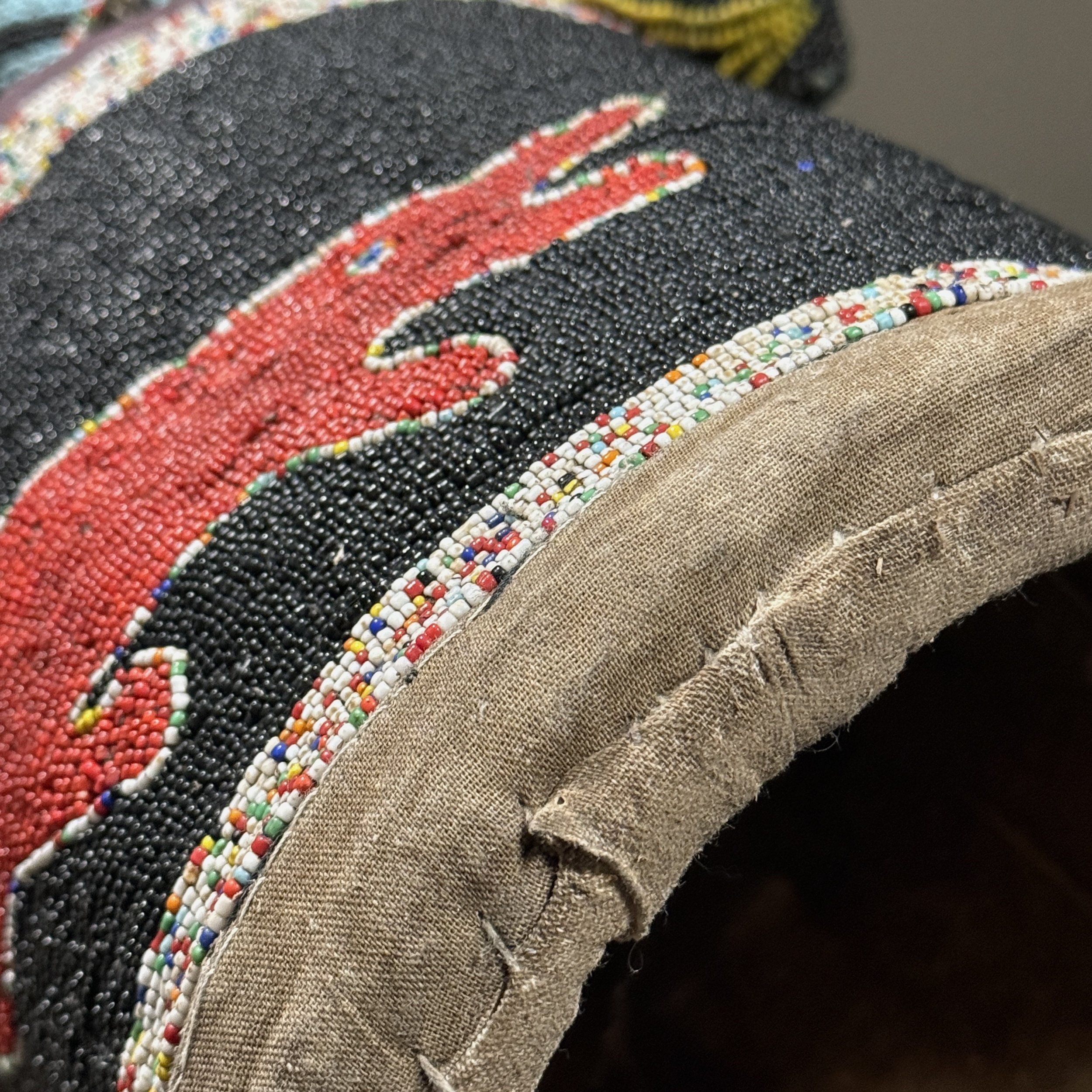 Close-up of beaded crocodile motif adorning the cylindrical base of a Yoruba royal crown