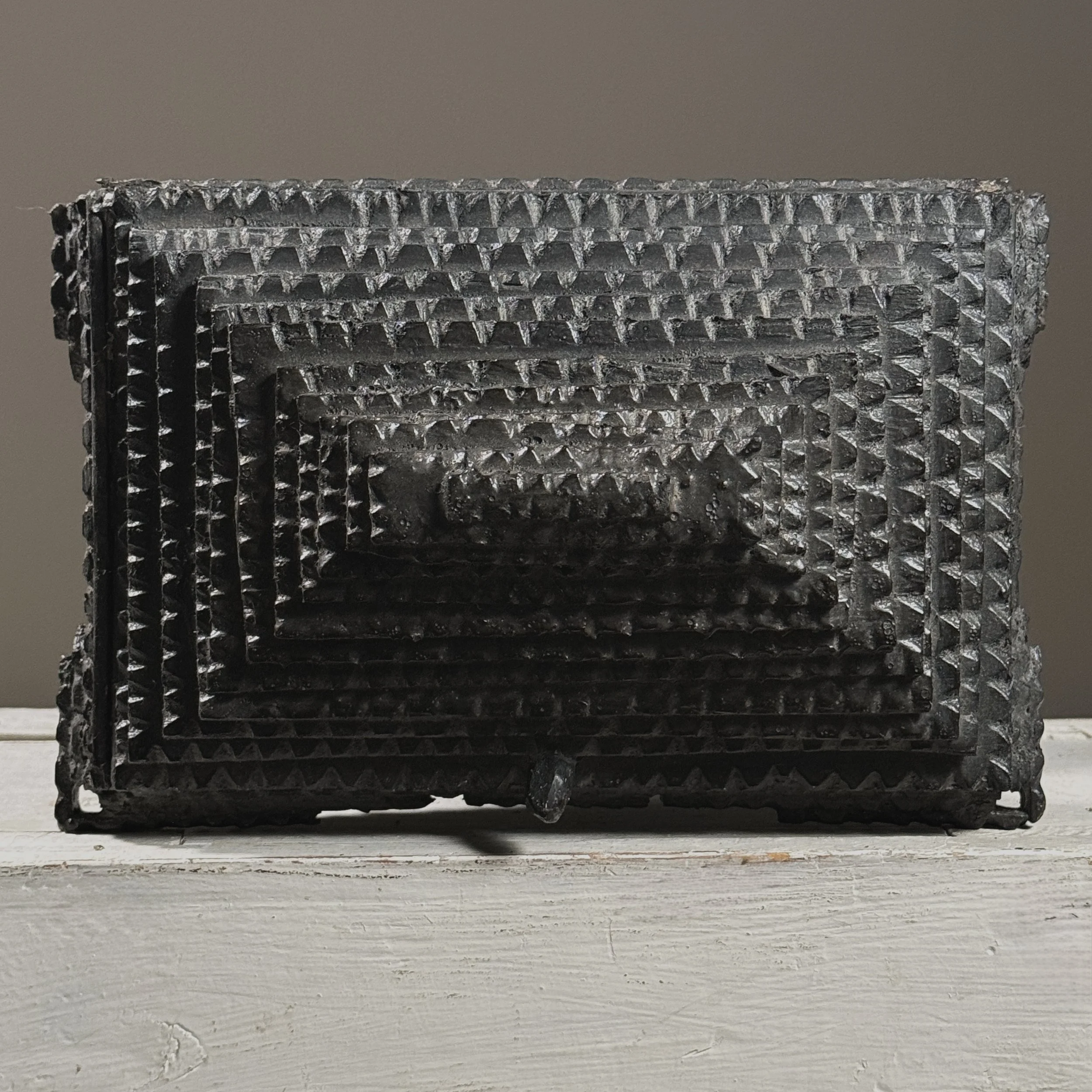 Elevated view looking down onto the top surface of a tiered tramp art box