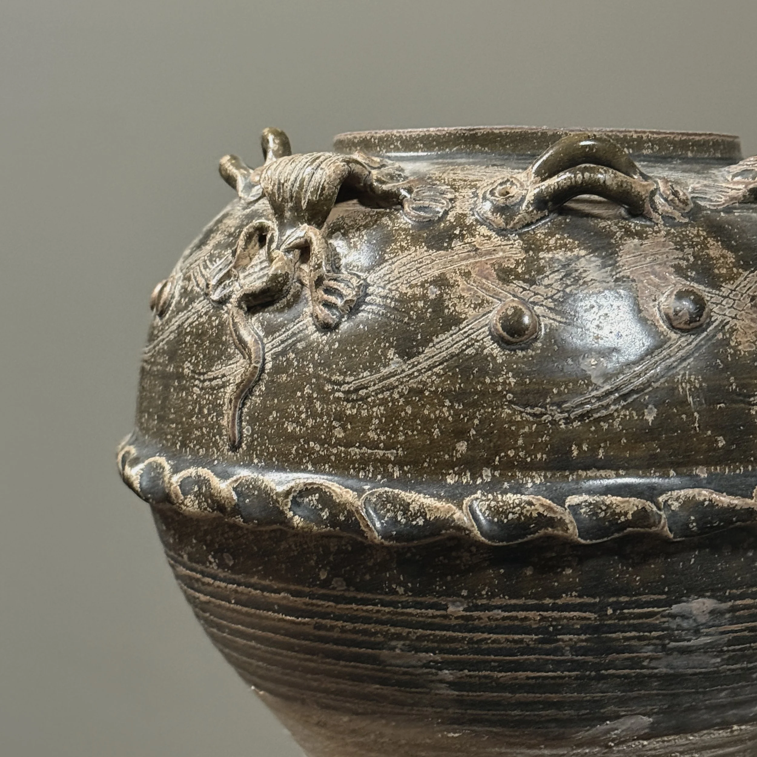 Detail of glaze texture and brownish-green coloration.