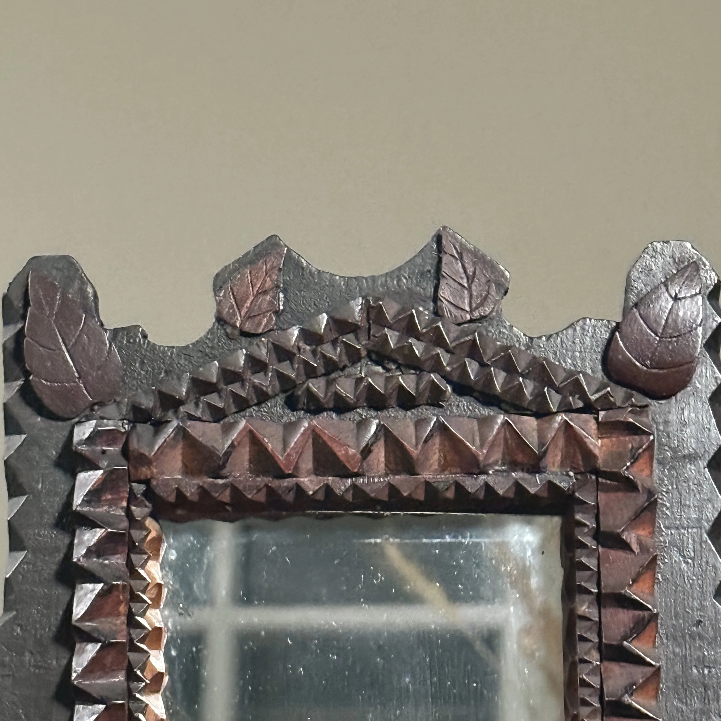 Close-up of the detailed chip-carving around the mirror frame.