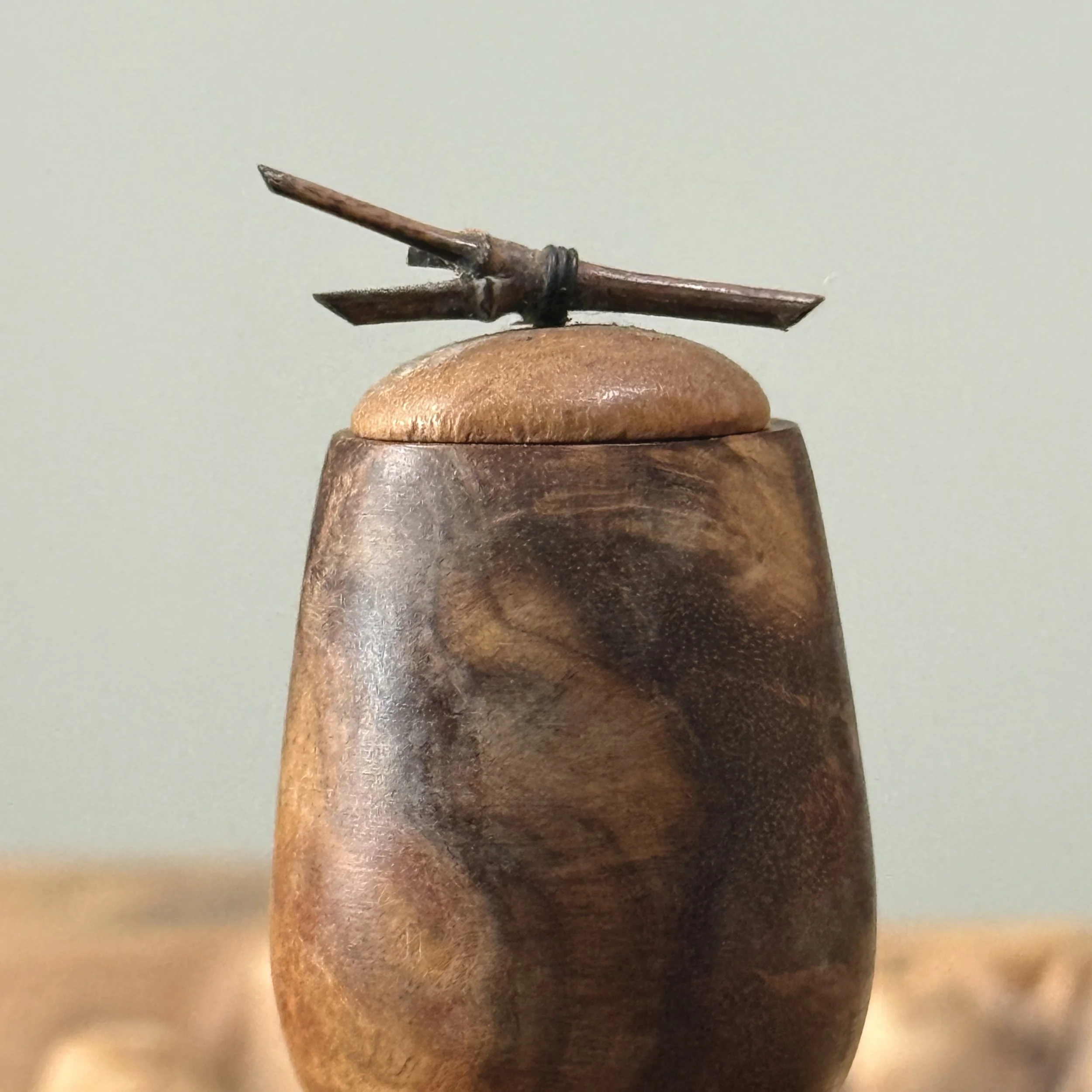 Close-up of twig finial. Small natural branch attached to center of lid.