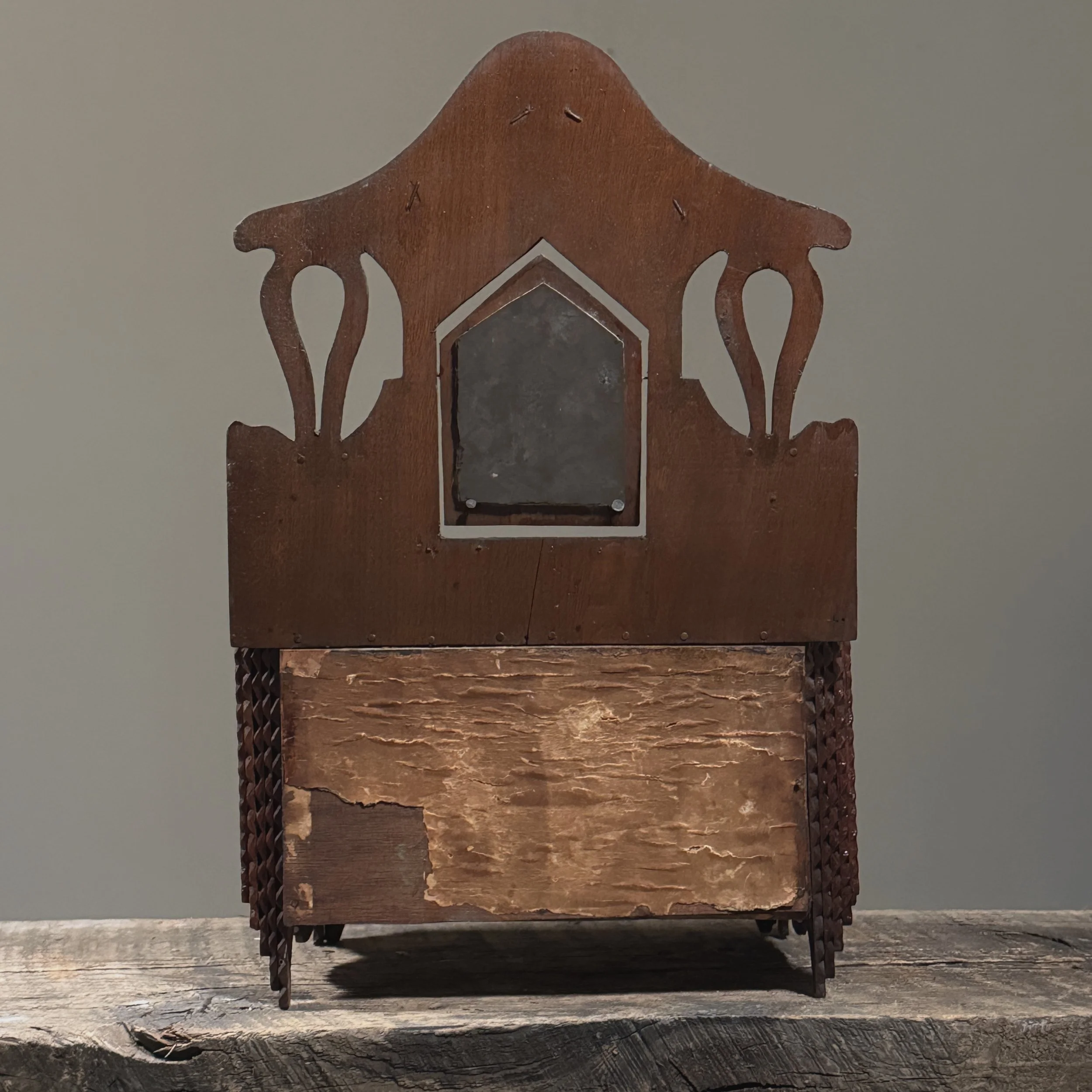 Back view showing hand-carved construction and patina