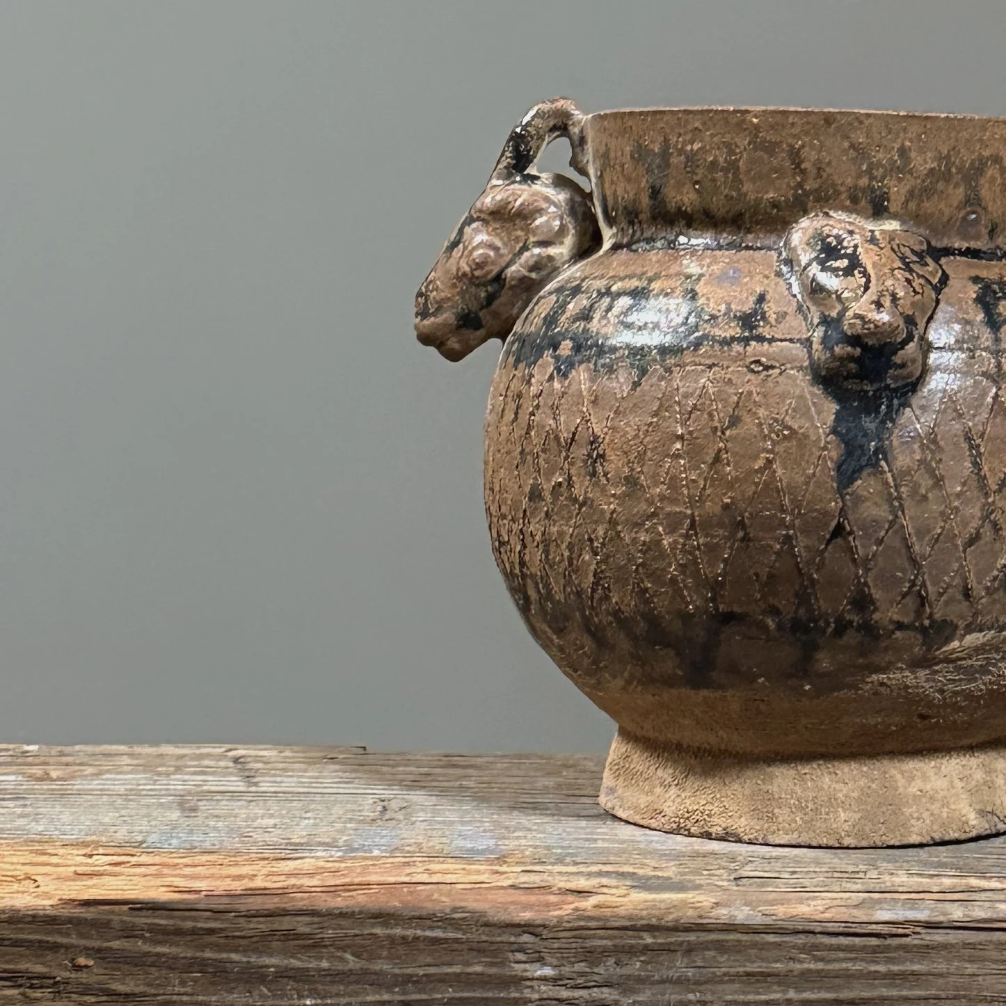 Close-up detail of one of the applied ram-head handles below the jar's rim.