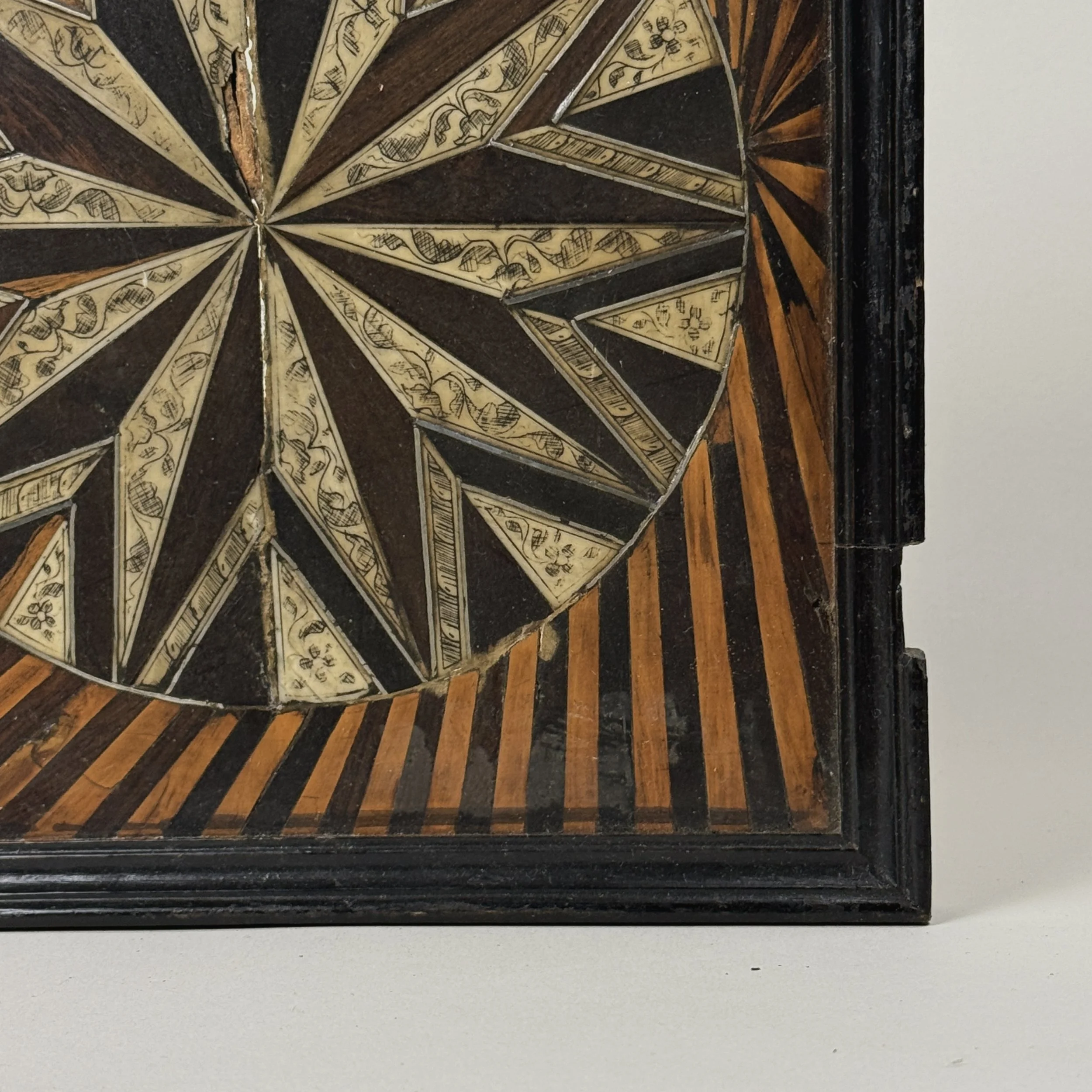 Sunburst detail. Geometric wood inlay. Symmetrical pattern.