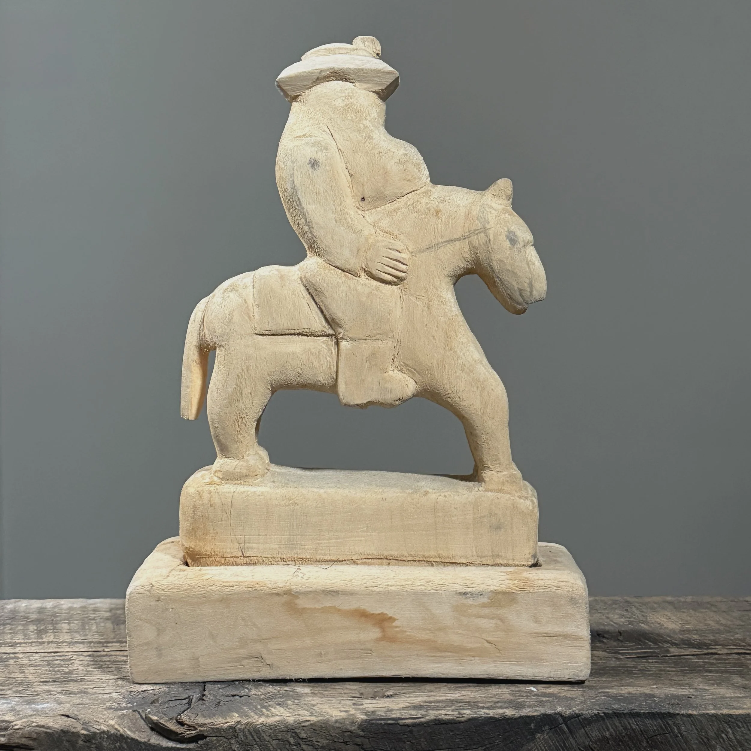 Rear view of the wooden sculpture showing the carving's craftsmanship.