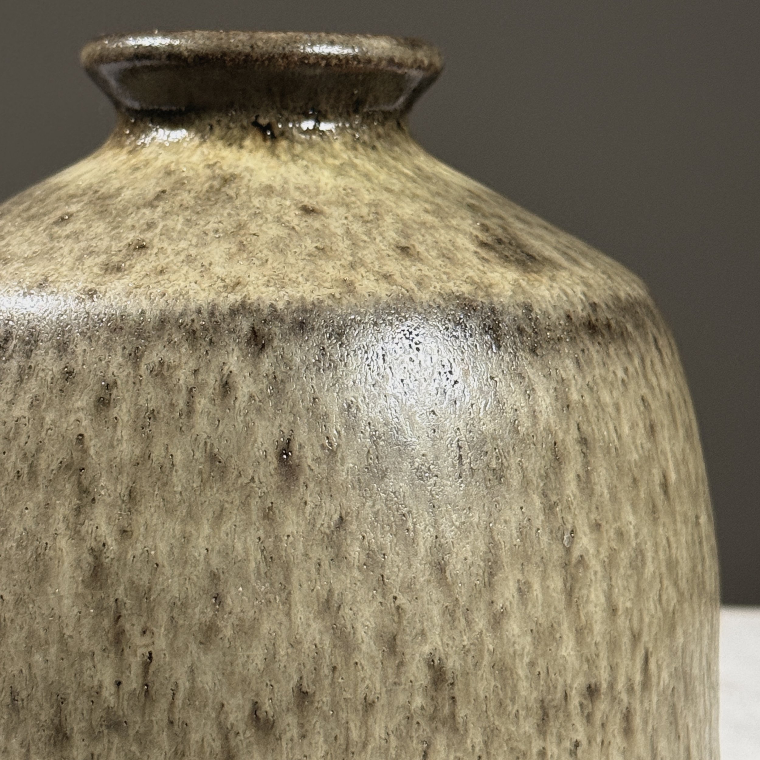 Close-up of pale green and brown glaze interaction.