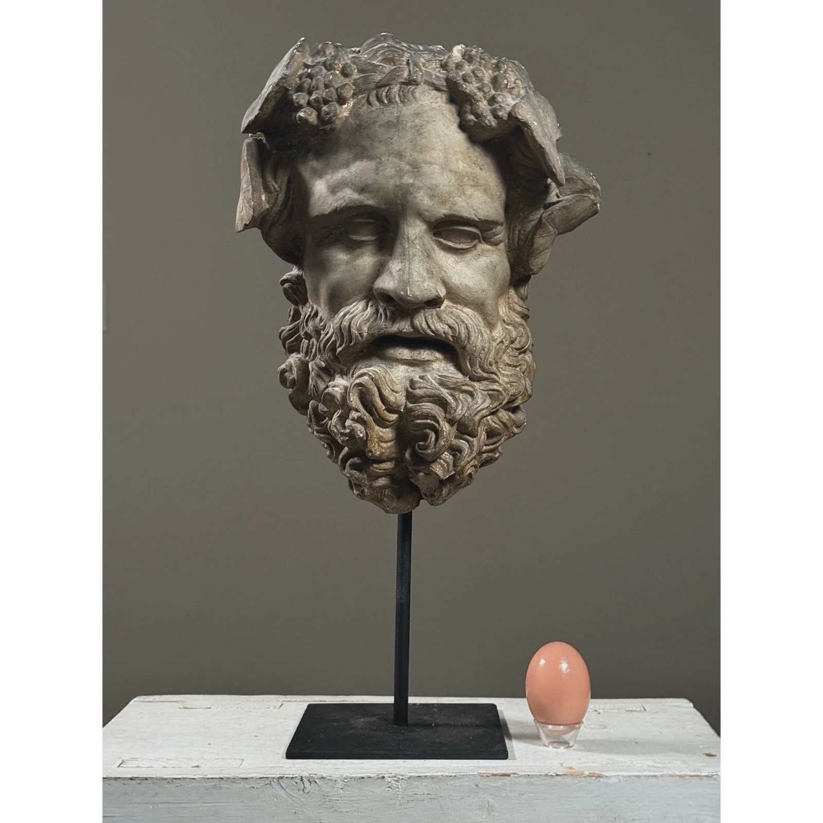 Antique neoclassical plaster mask of the mythological figure Silenus with egg.