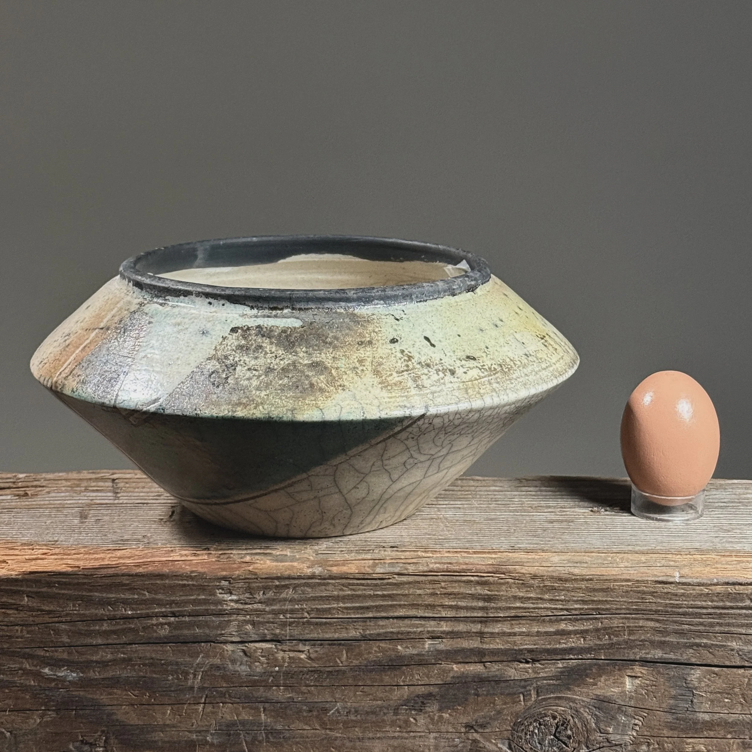 Vintage Japanese Raku fired crackle glazed vessel with egg for size reference.