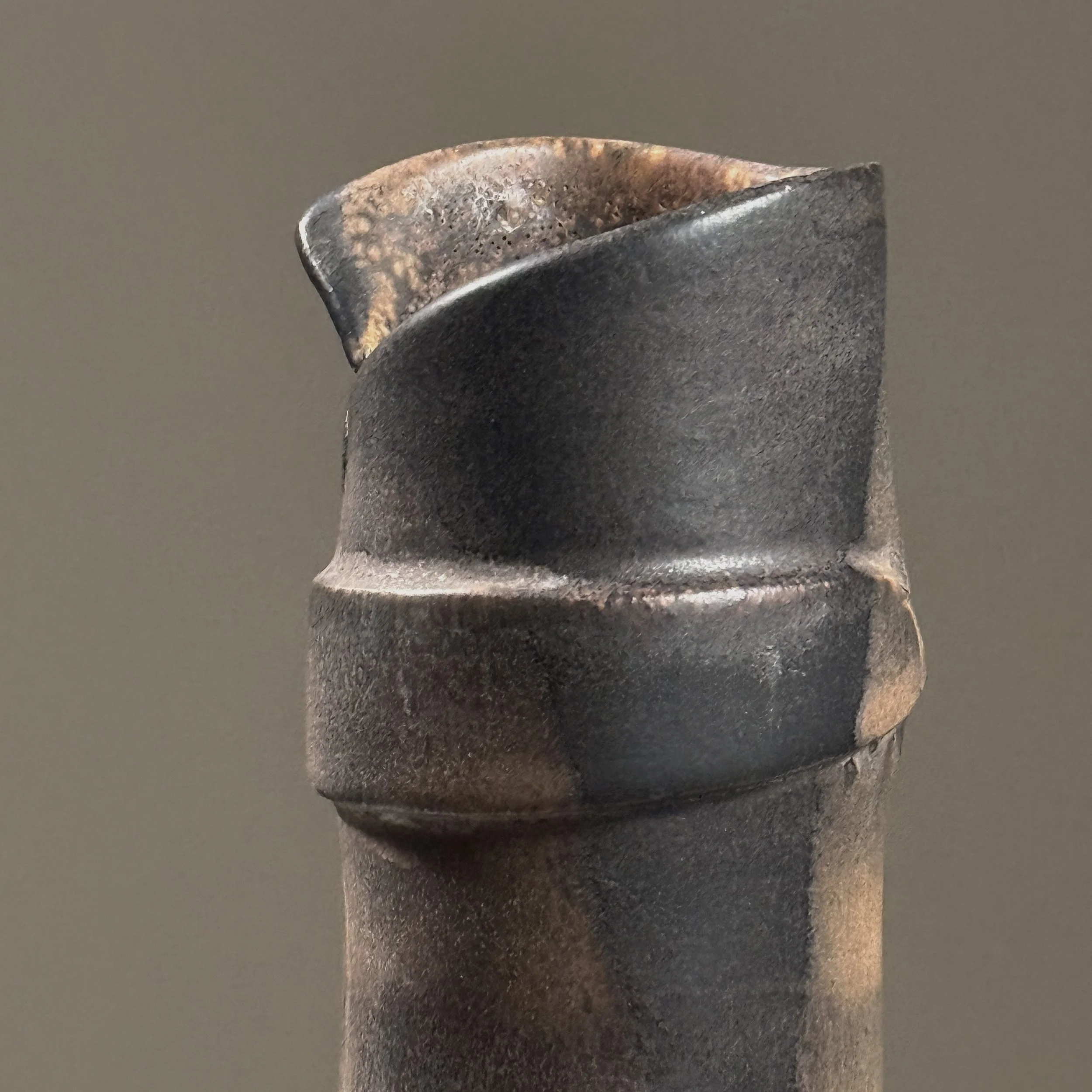 Detail of the fold-like sculptural element on the vase exterior.