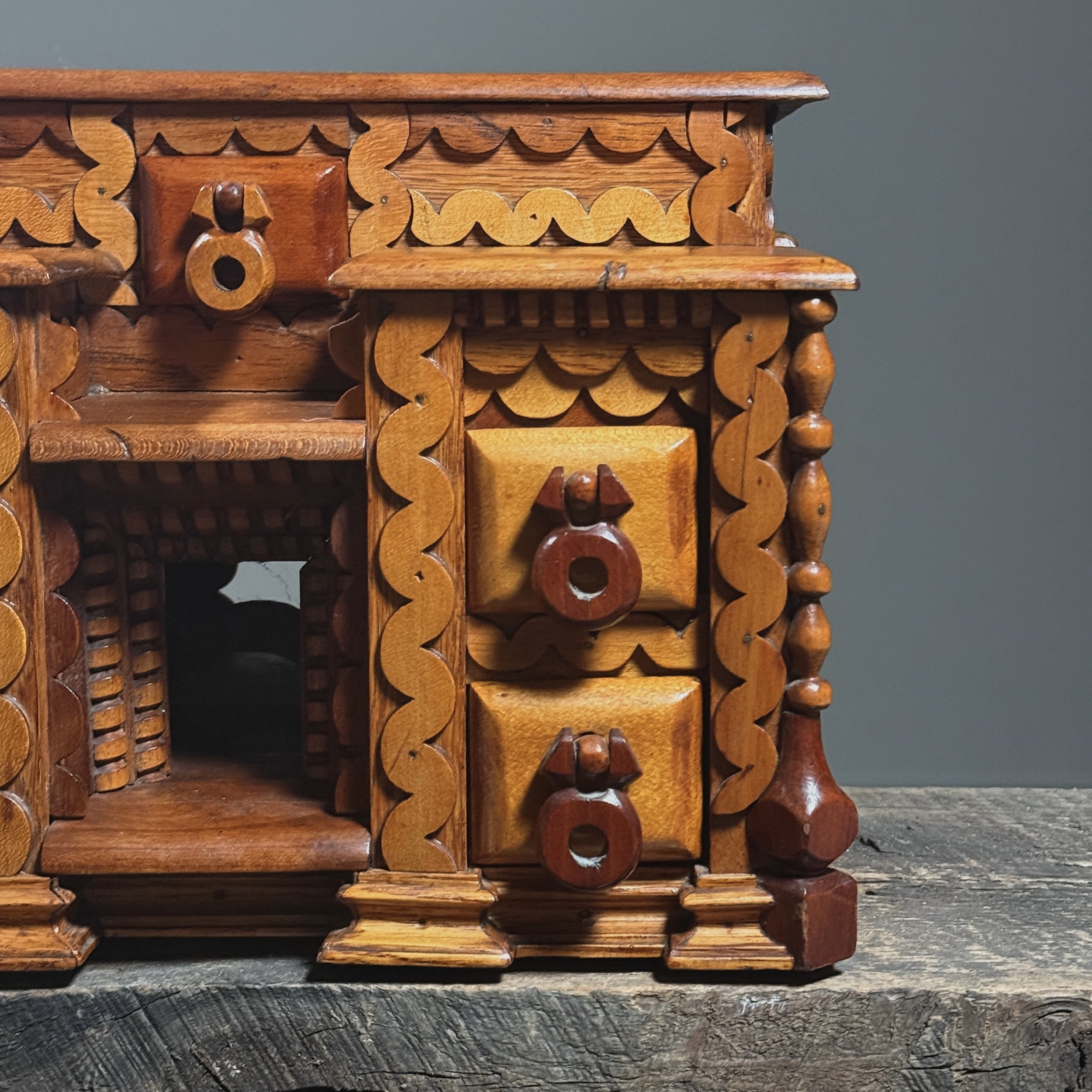Close-up detail of layered "squiggly" scrollwork ornamentation on a vintage folk art box