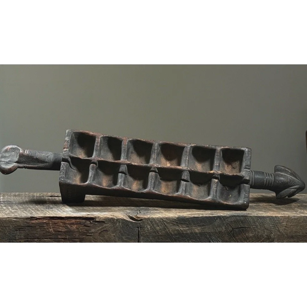 Top view of mancala game board showing carved game pits and patina