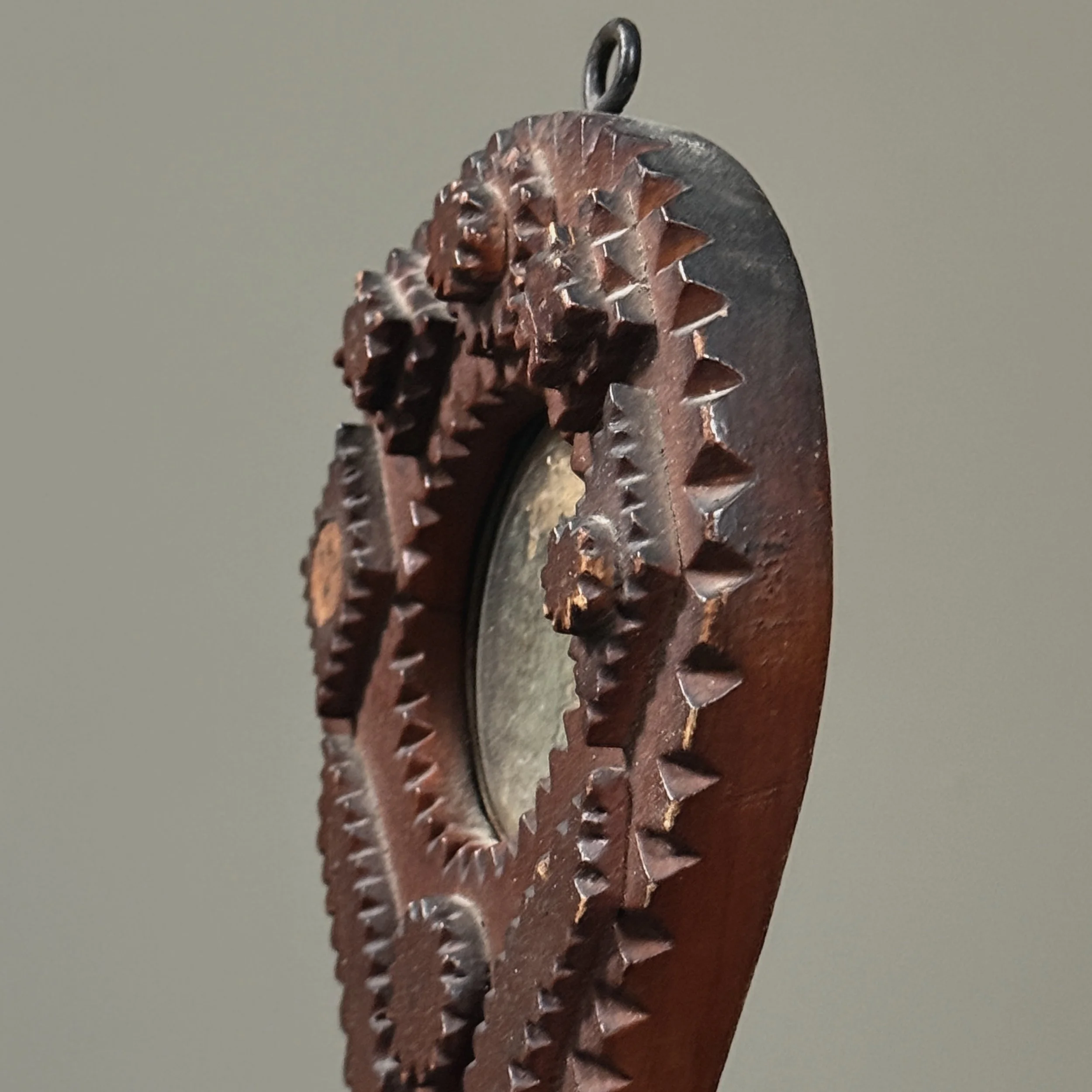 Aged mirror with worn silver backing in Tramp Art wall pocket