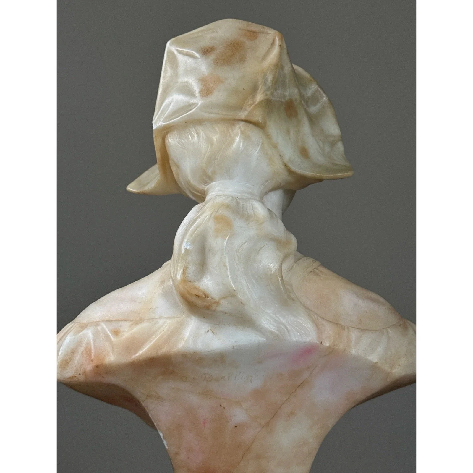 Close-up back detail of the woman's softly carved facial features and expression.