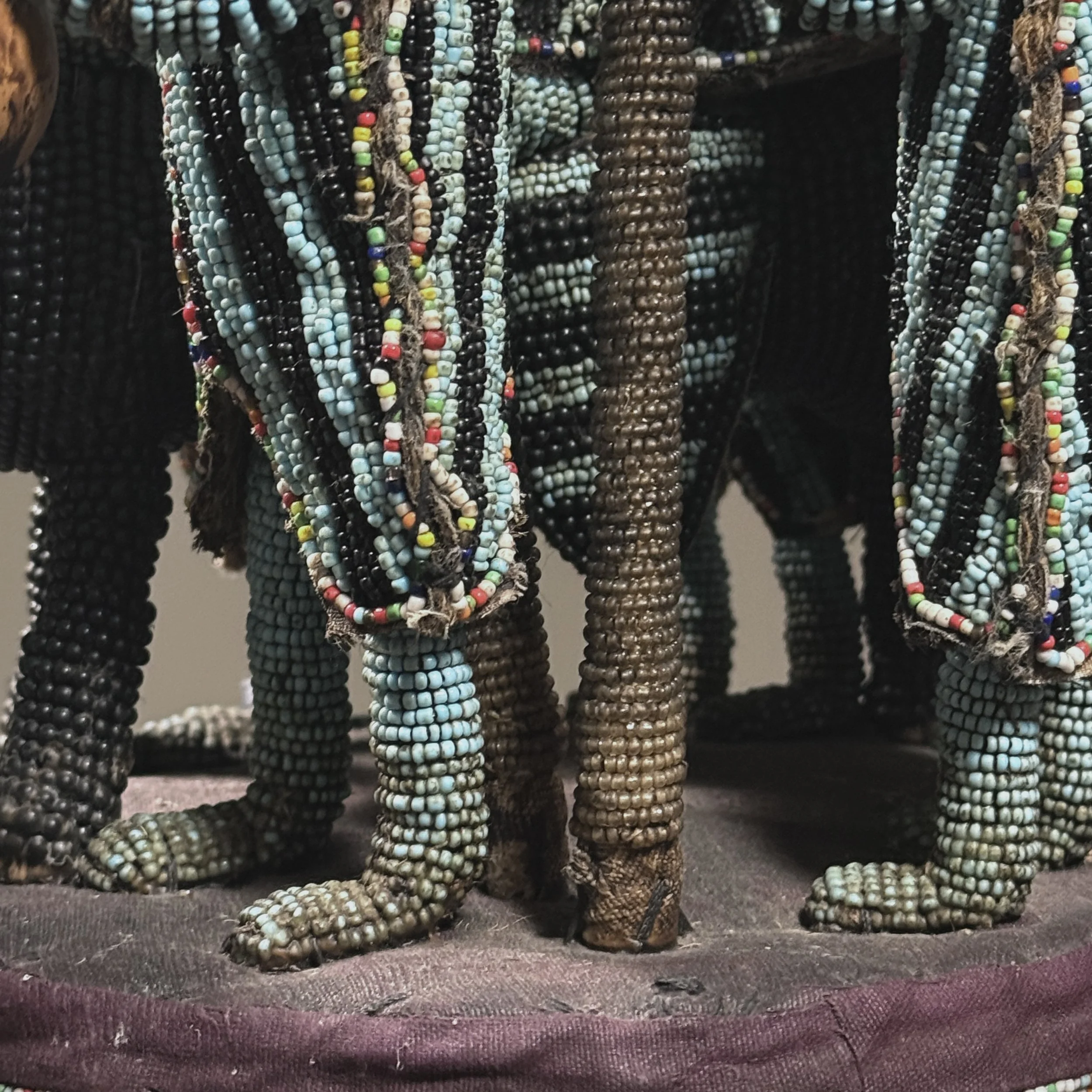 Detail of flanking attendant figures bearing gourds and wands on a vintage African headdress