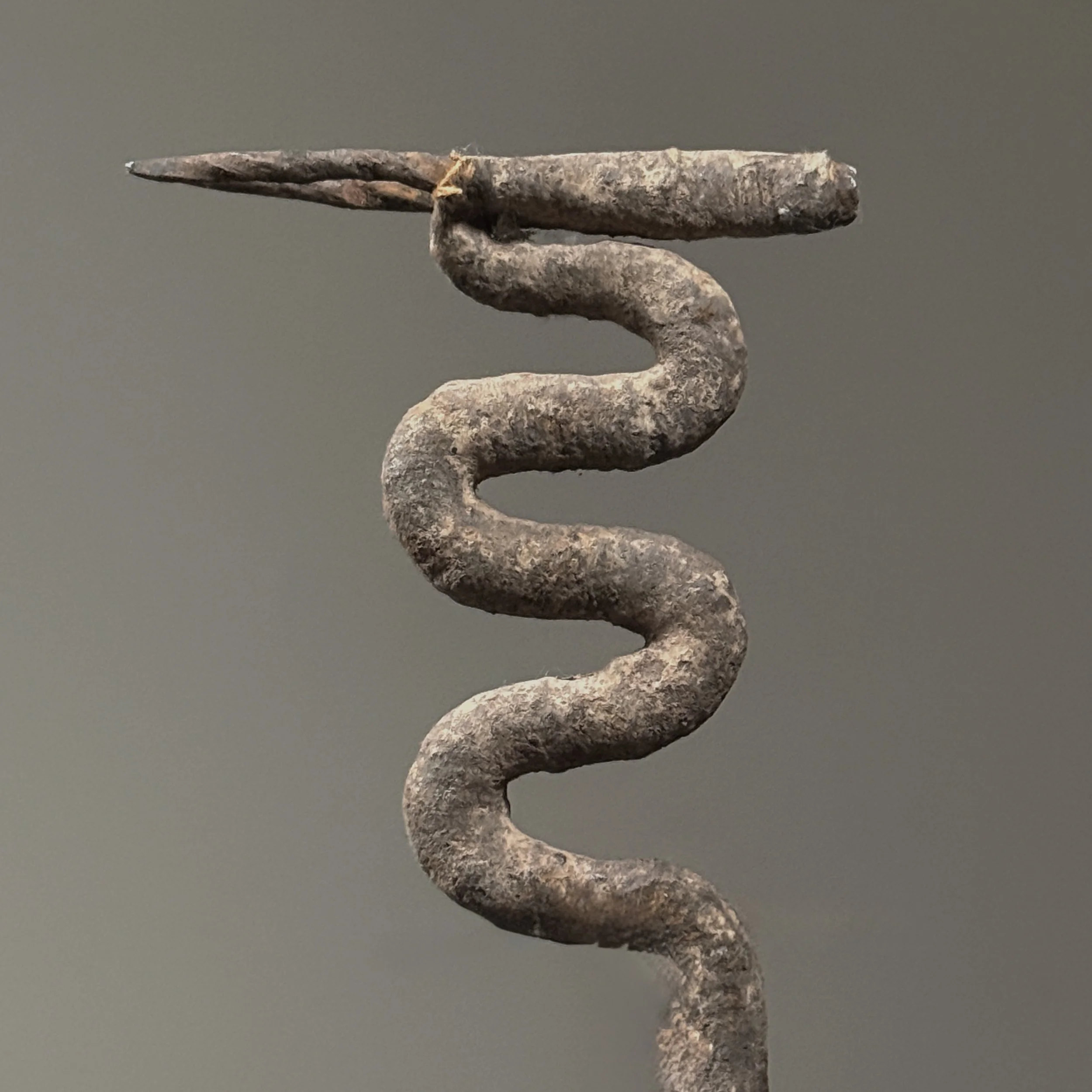 Close-up of antelope head. Wrought iron silhouette rising above snake body.