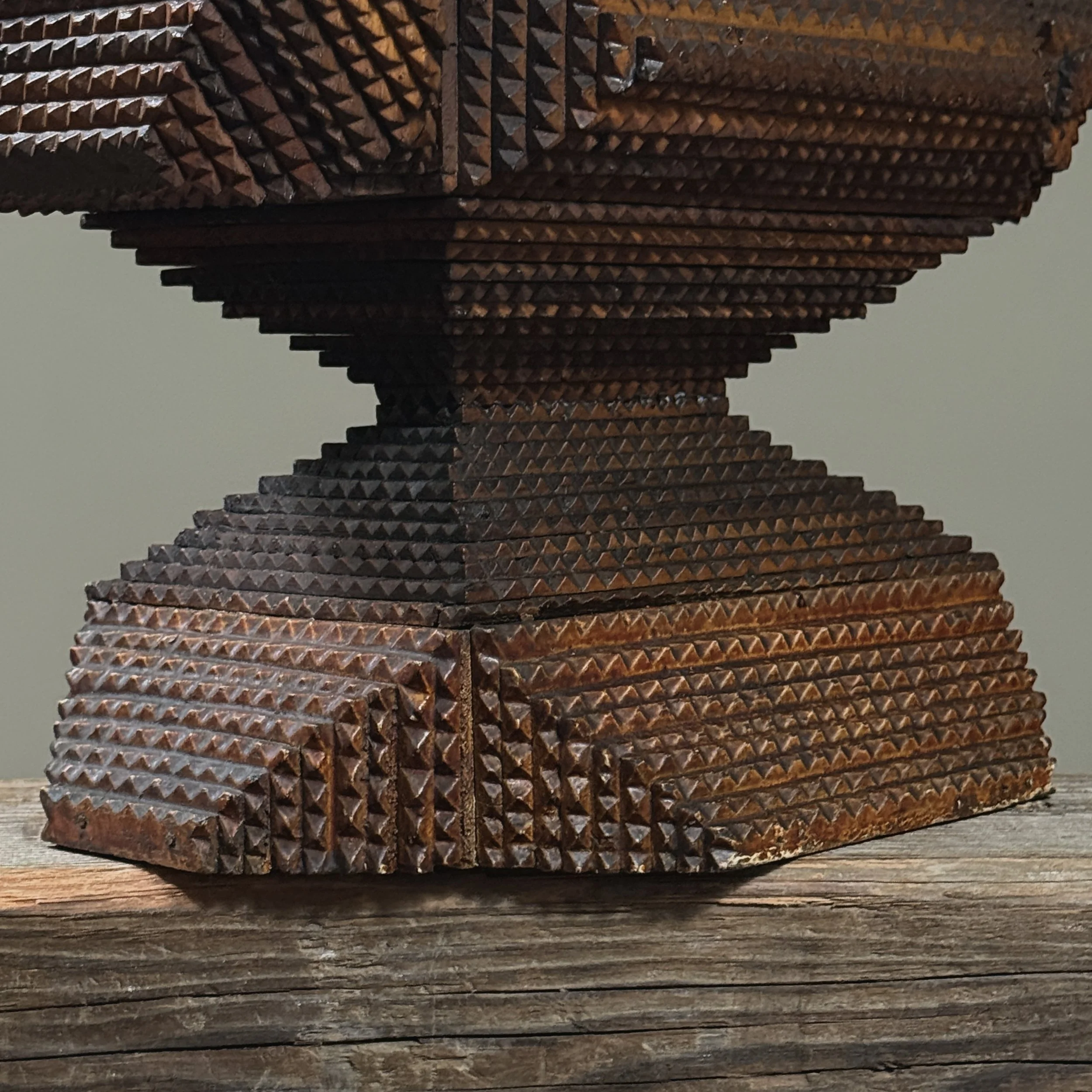 Close-up of layered pyramid carving with 19th-century folk art detail