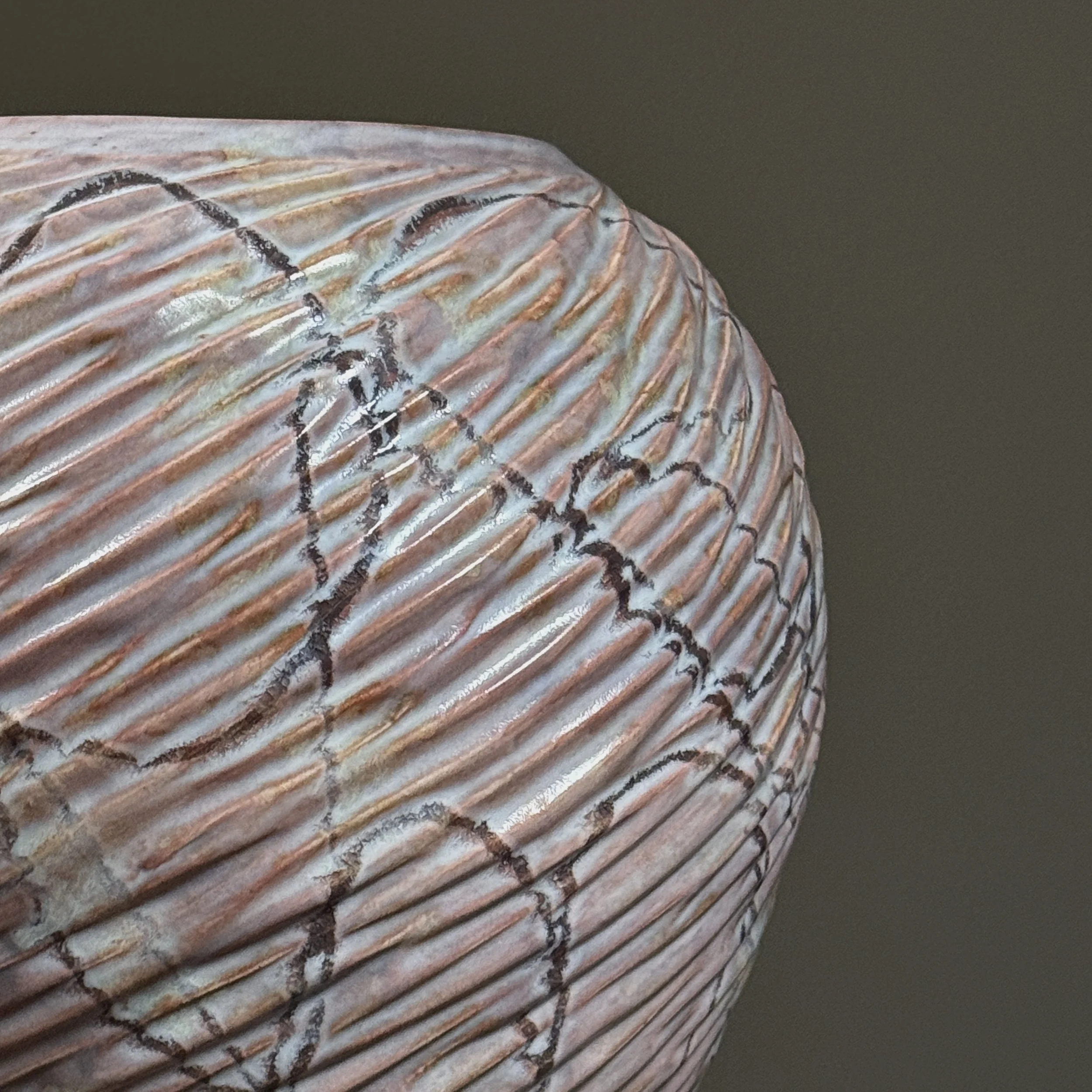 Close-up of ribbed ceramic texture with pink and gold coloration