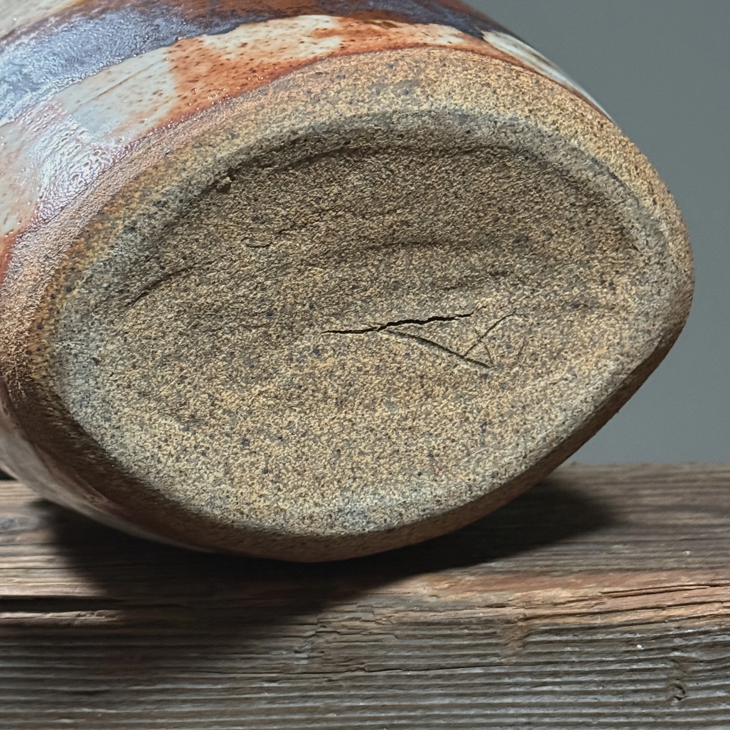 Bottom of vessel. Chop mark impressed into clay.
