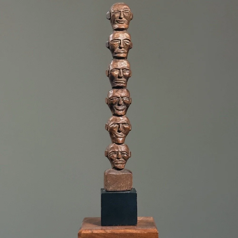 Antique hand-carved wooden head totem on black base