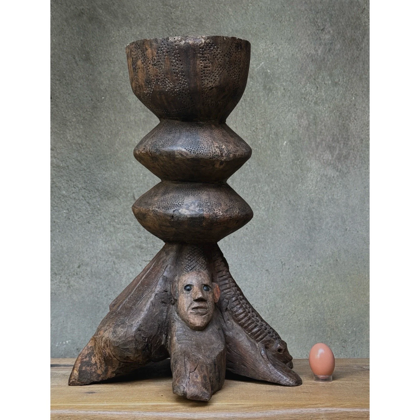 Vintage hand-carved folk art wooden sculpture with egg for size reference.