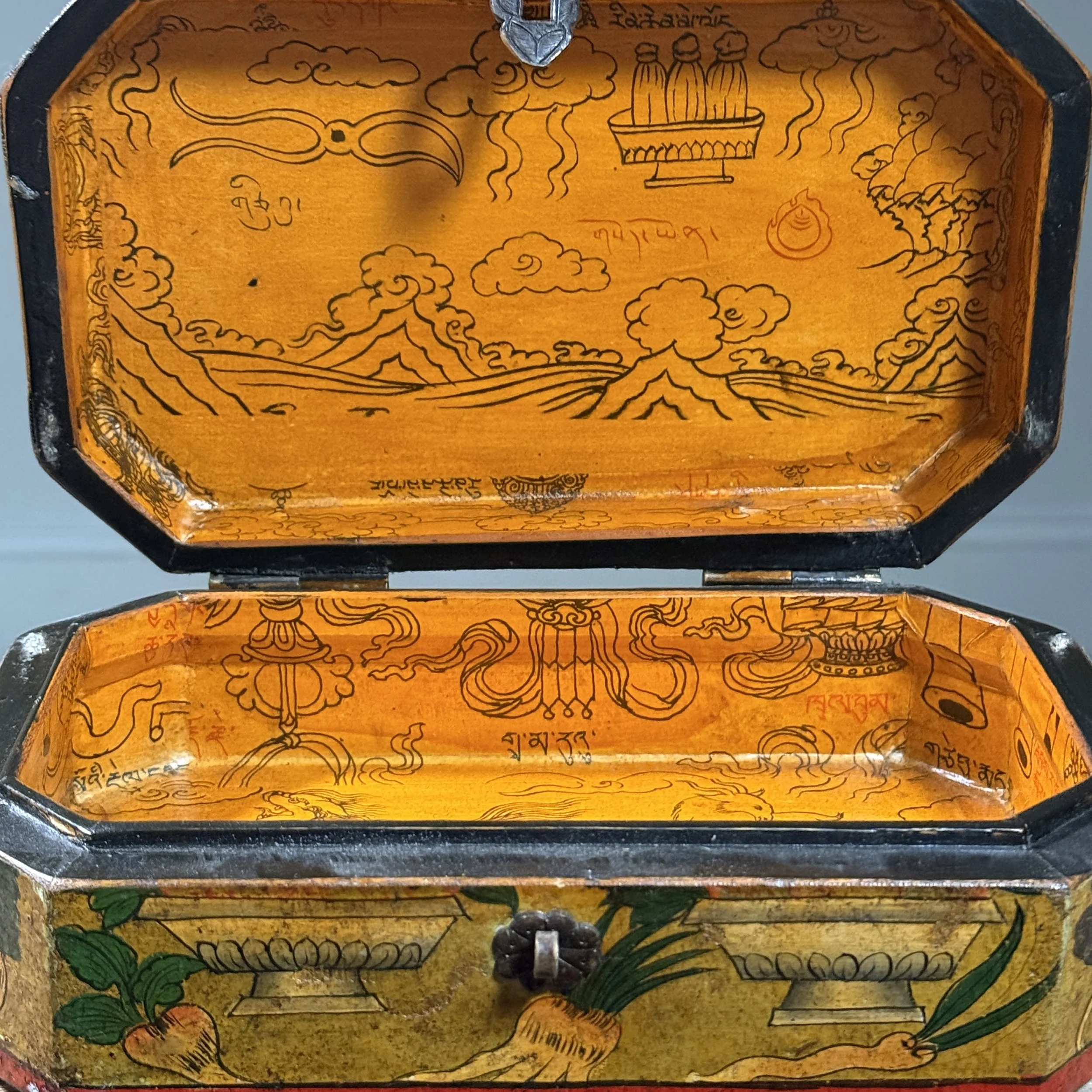 Box open. Interior skinned with Indian illustrations. Yellow fabric visible.