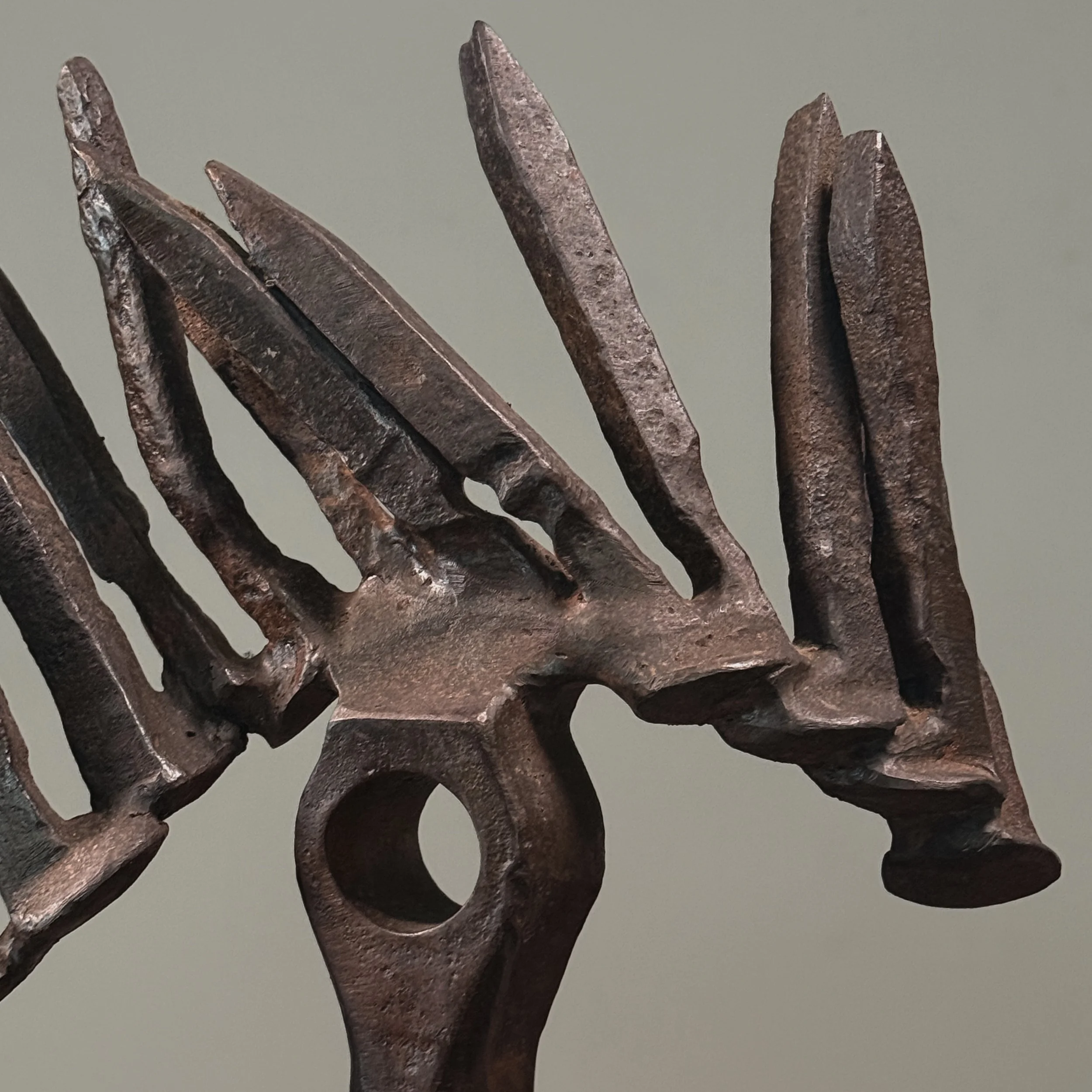 Close-up of forged iron elements. Raw material texture and industrial finish visible.