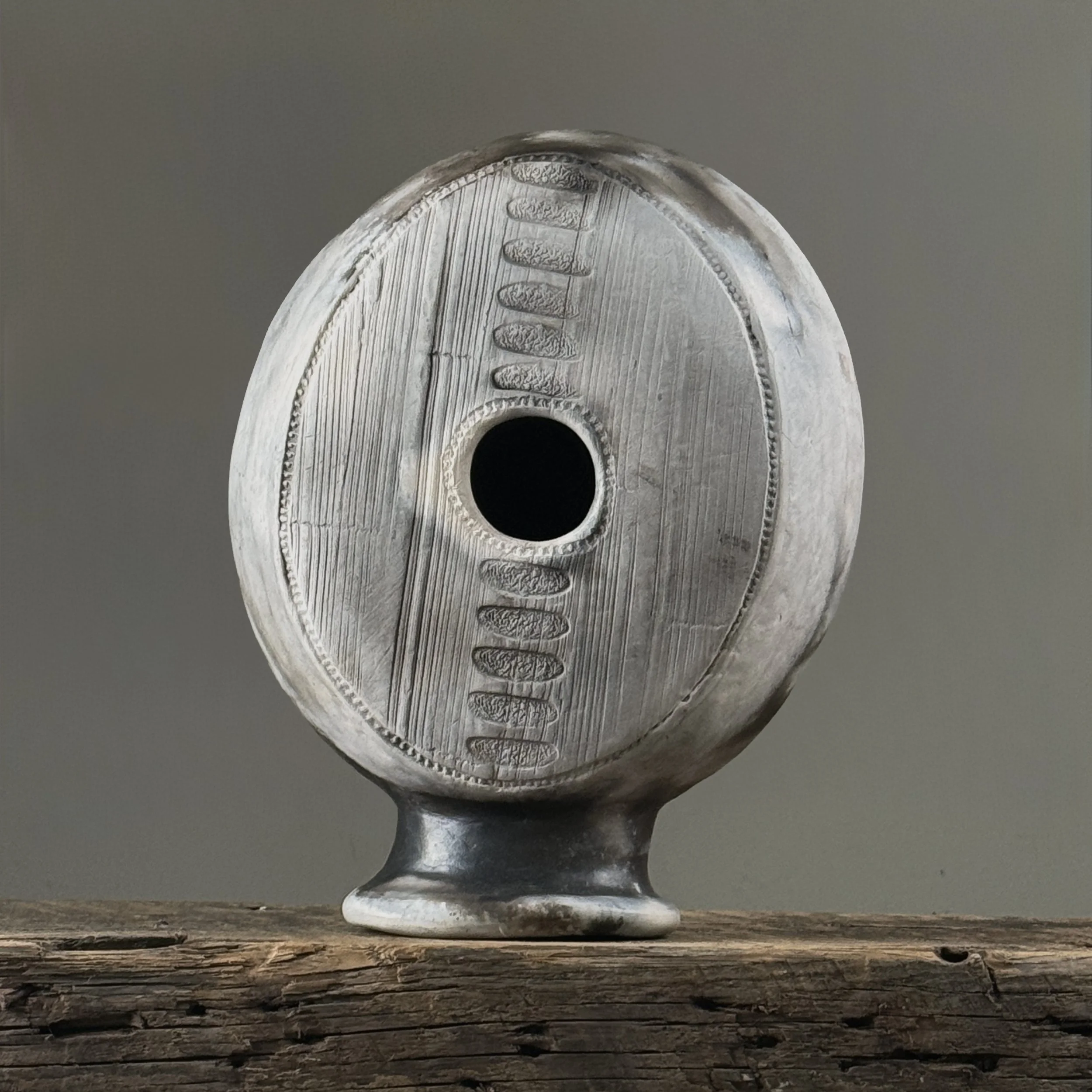 Vintage raku fired vessel with hole in center, signed with maker's mark