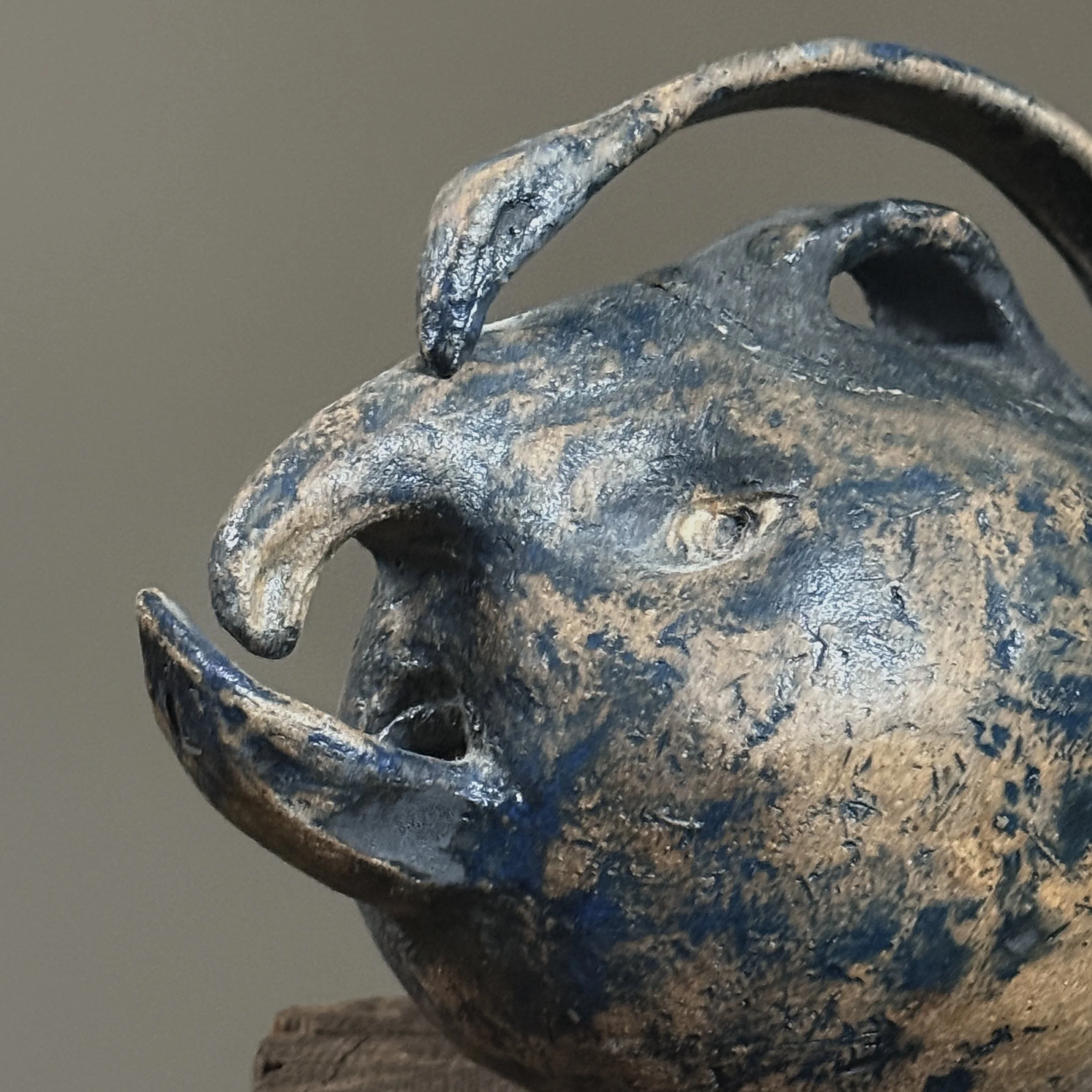 Studio pottery teapot with nose, eyes, and mouth spout