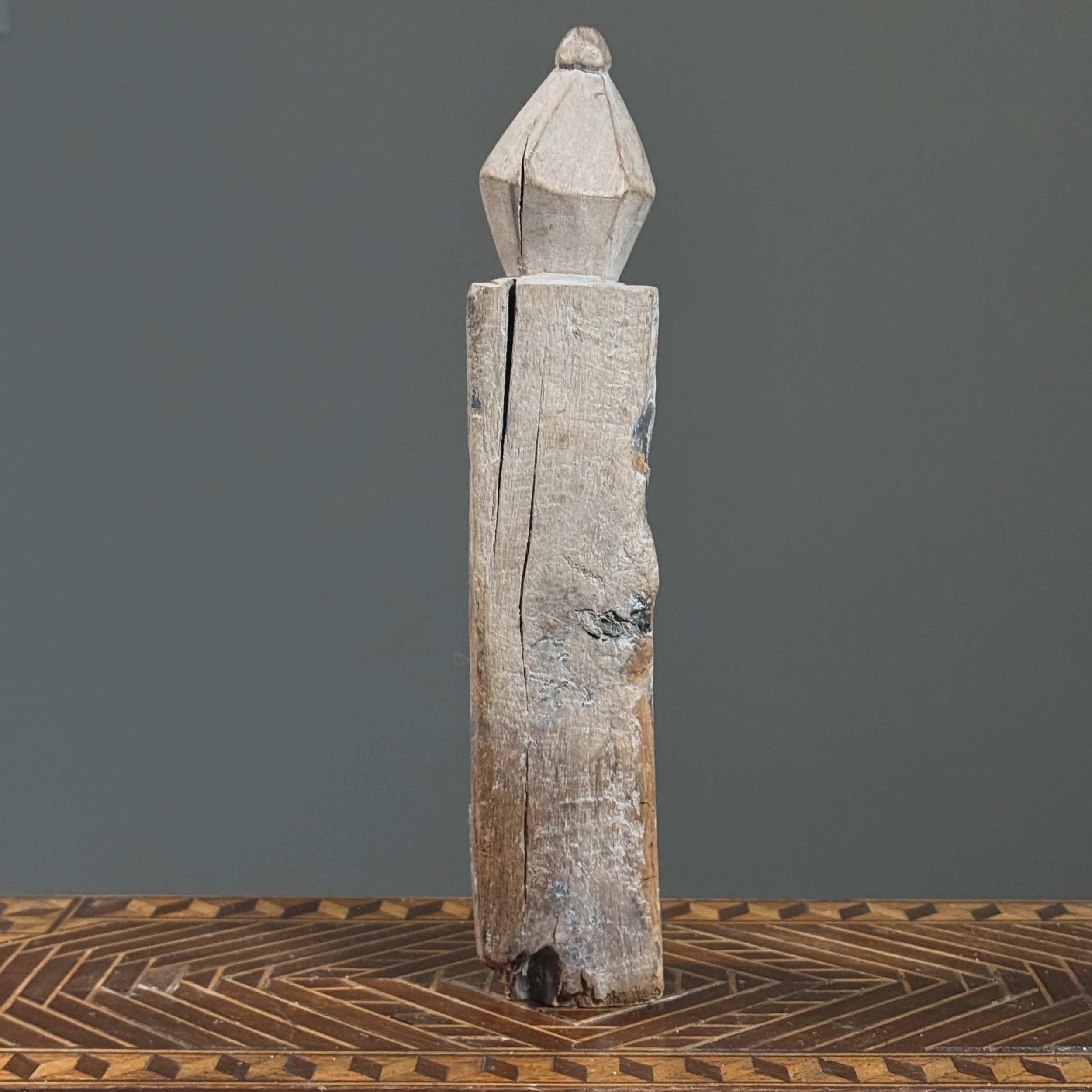 Whitewashed Indonesian wooden figure finial, back view.
