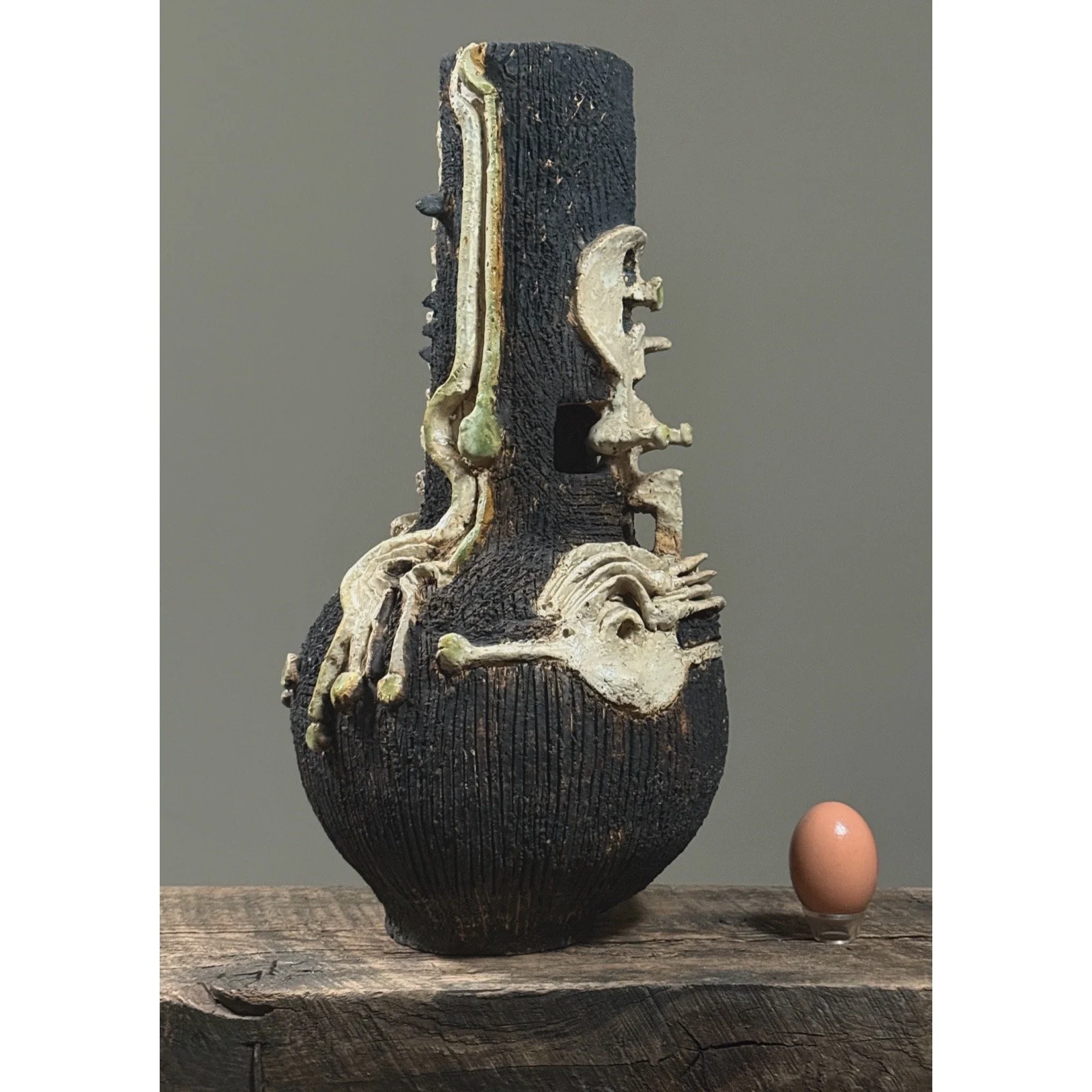 Architectural vase with a memento mori skull design egg and textured striations.