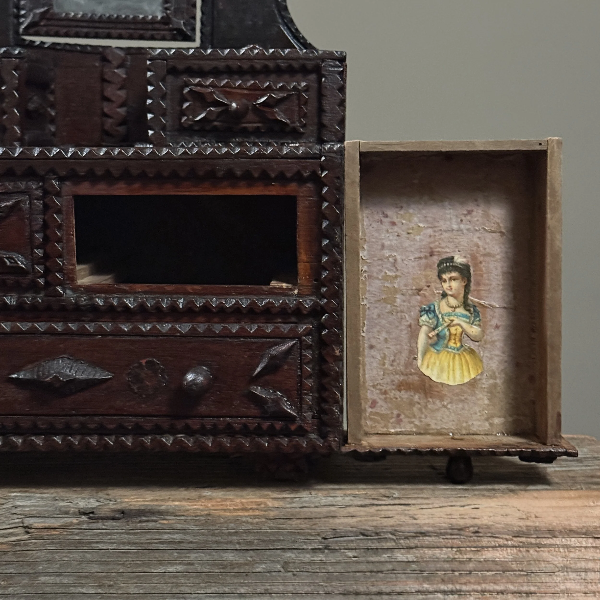 Interior view of large bottom drawer with decoupage elements visible