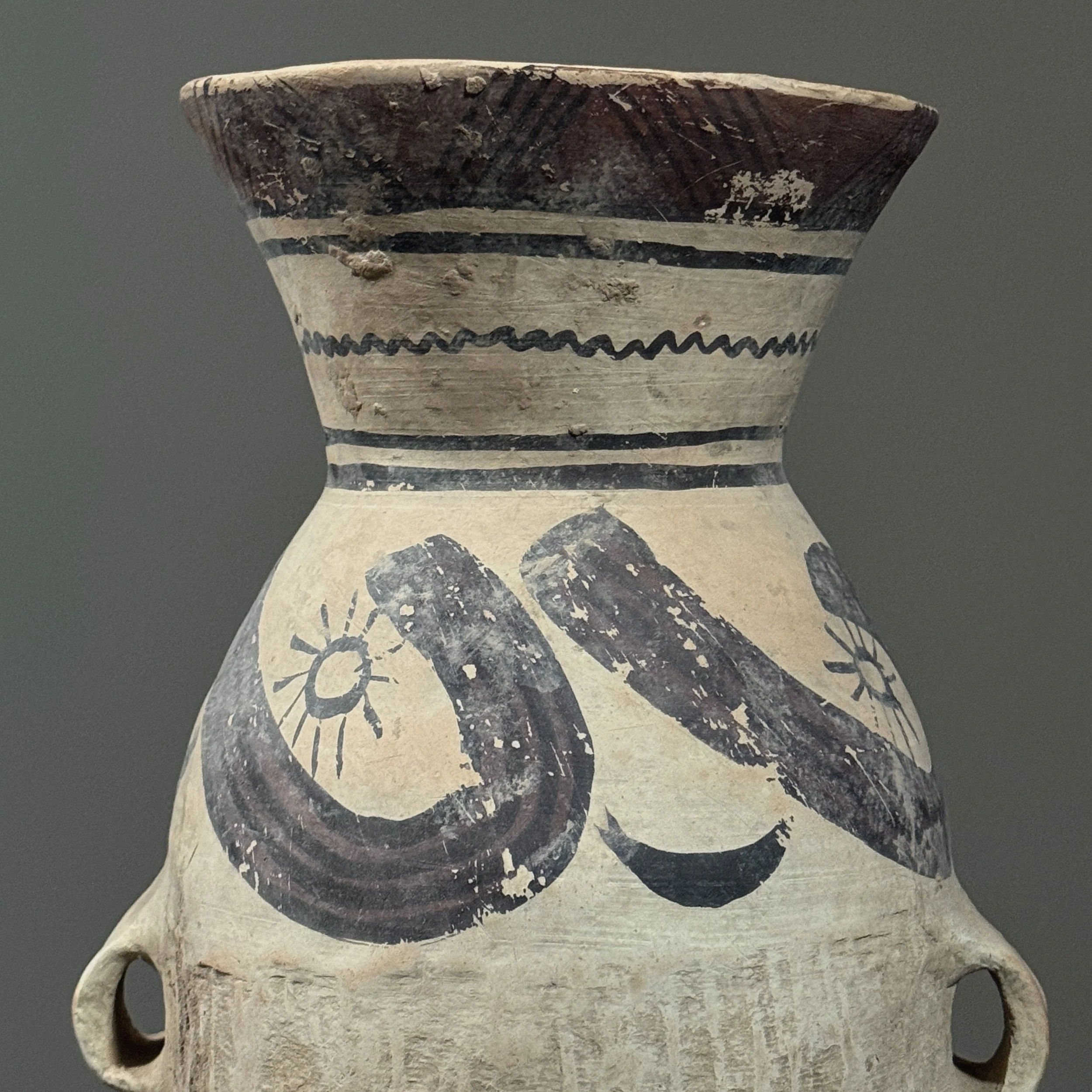 Detail of moon and wind designs on earthenware surface