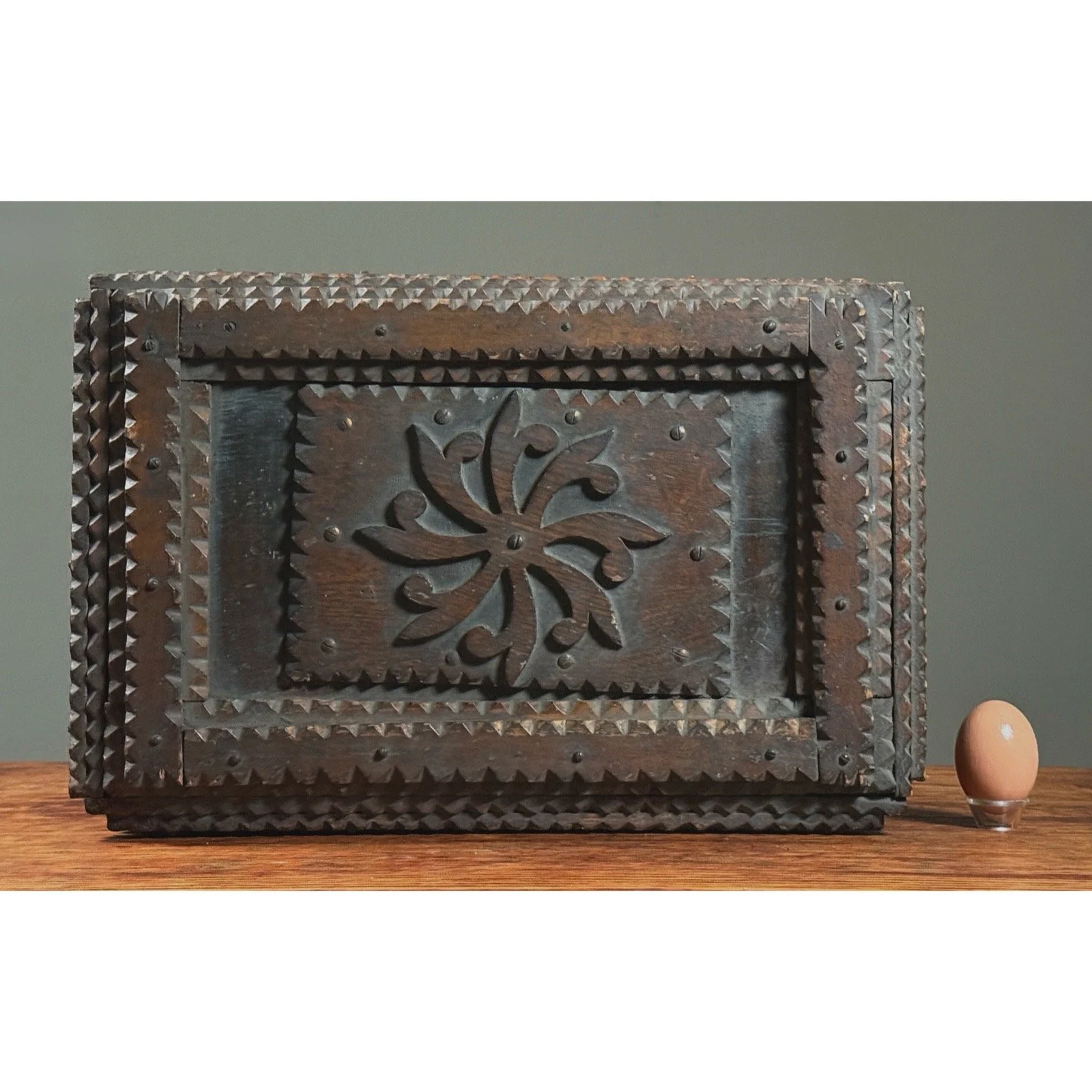 Monumental antique tramp art chip-carved chest, with egg for scale.