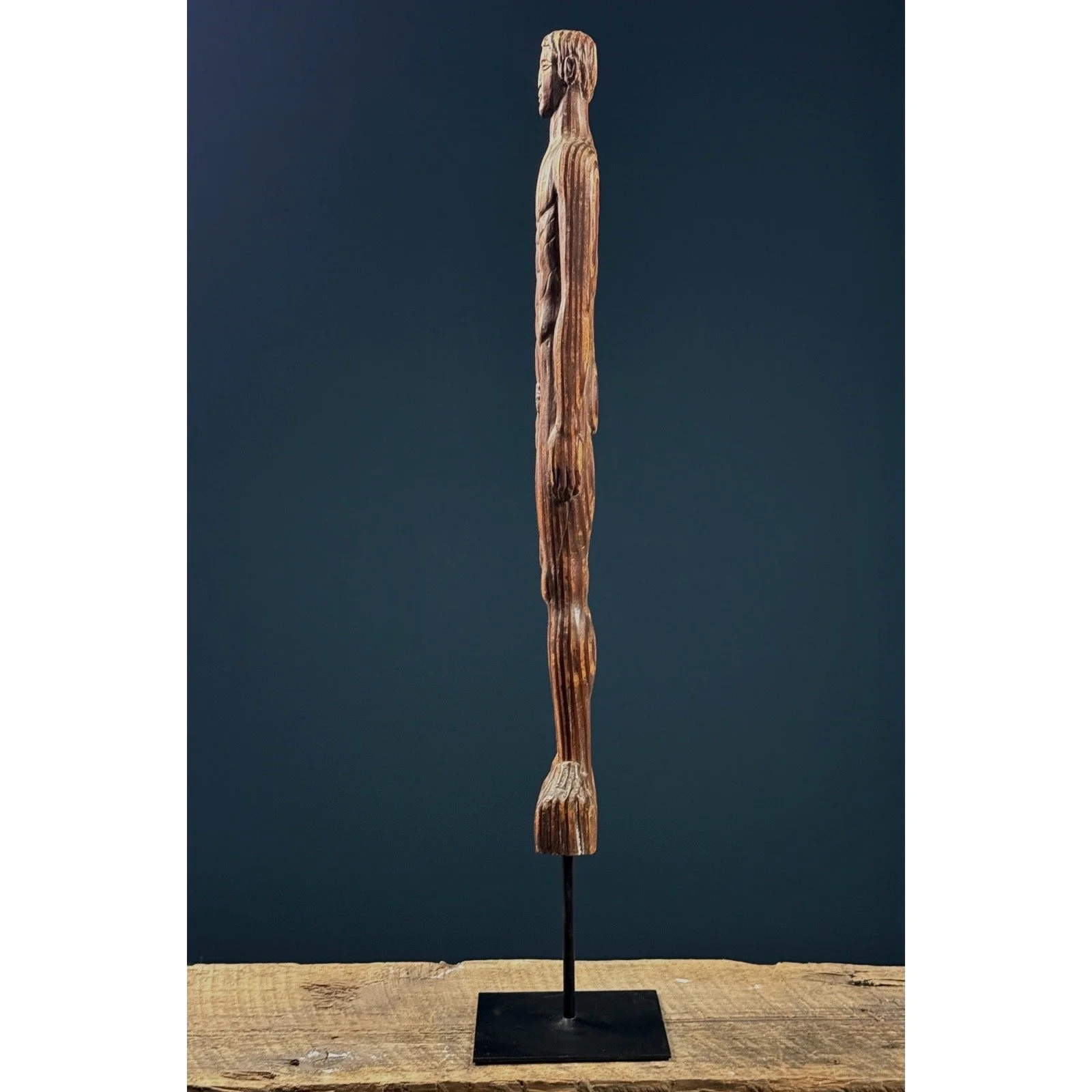 Side profile emphasizing the figure's verticality and wood grain.