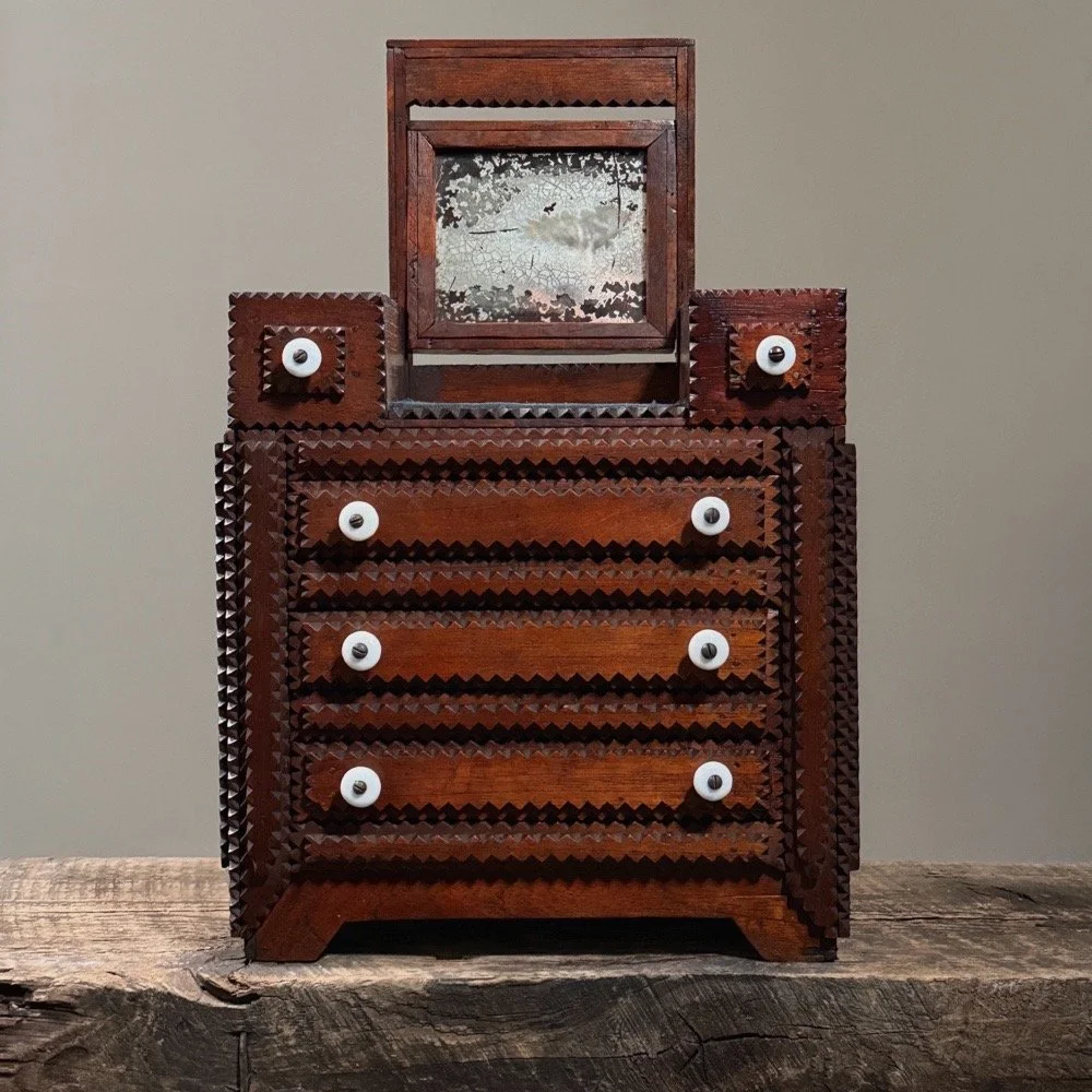 Antique Tramp Art tabletop dresser with hinged mirror on a neutral background.